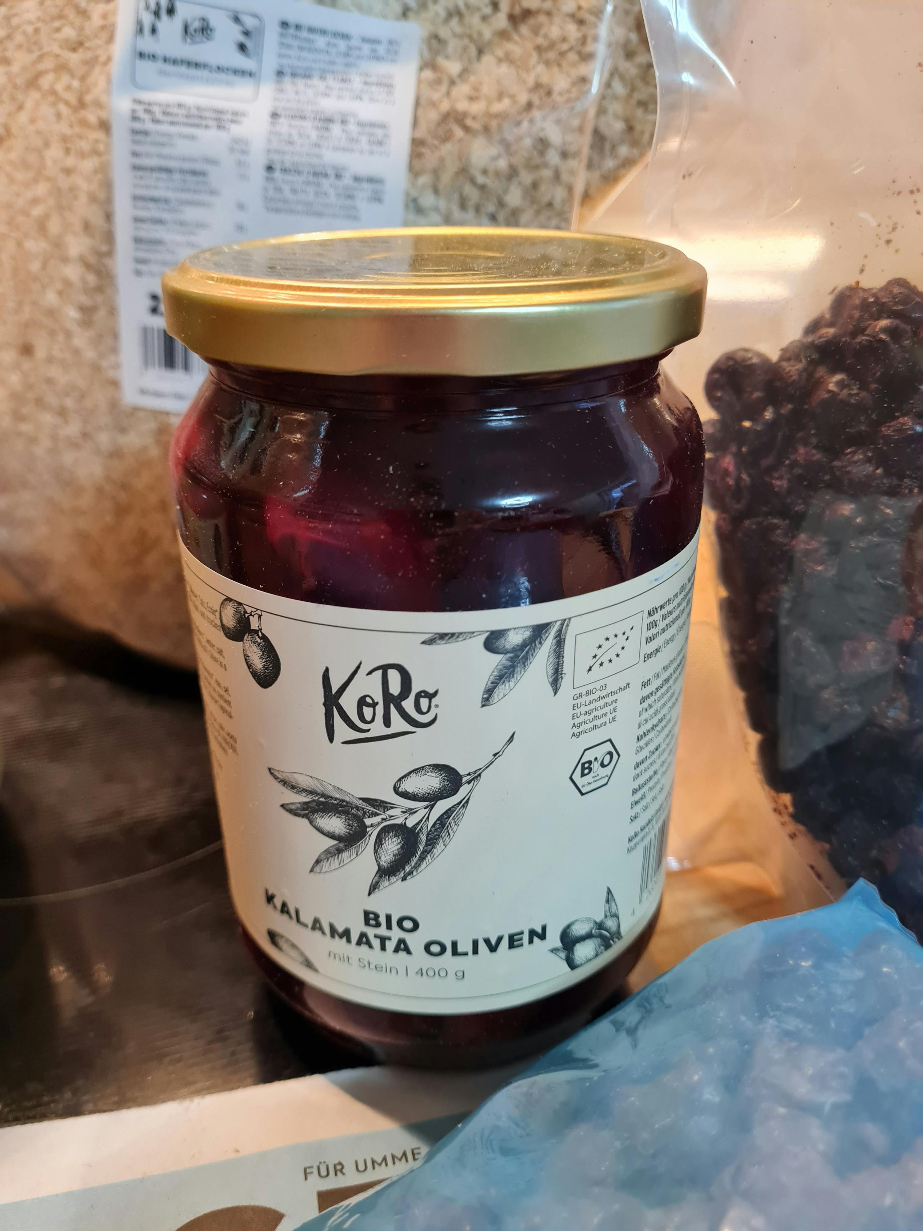 ein Glas Karamata Oliven mit einem goldenen Deckel