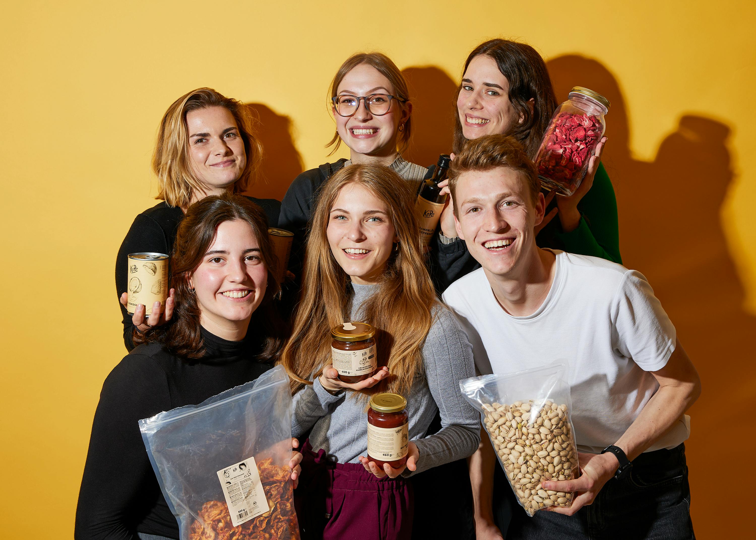 un gruppo di giovani in piedi uno accanto all'altro e in possesso di prodotti alimentari