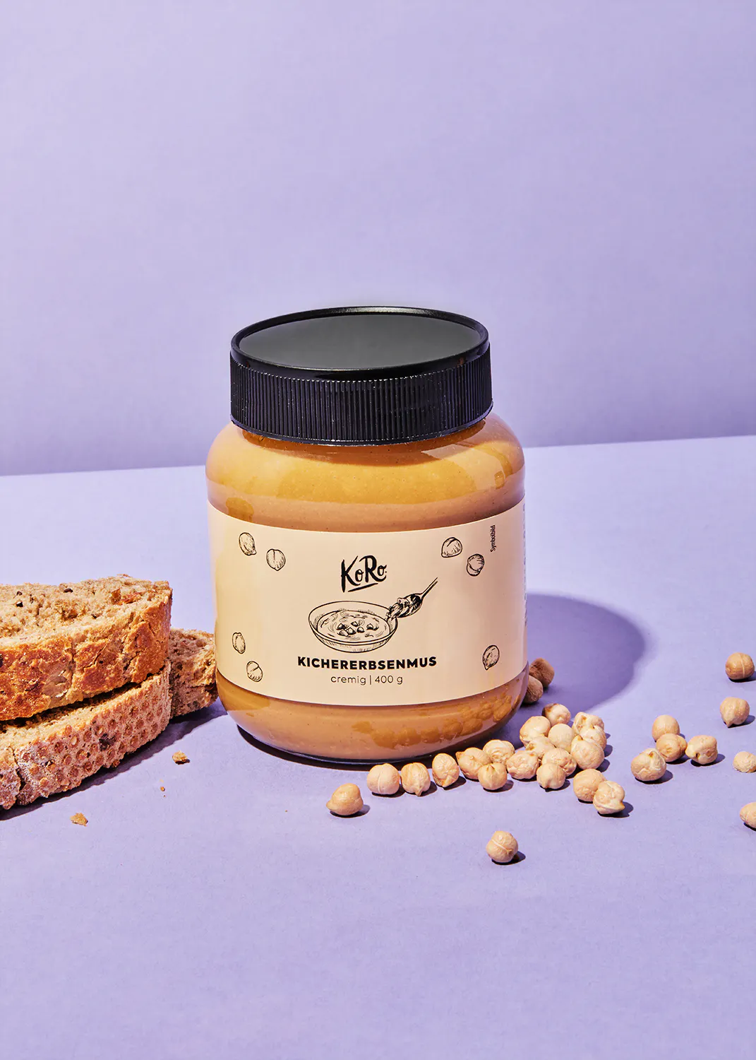 a jar of kichererbsenmus sits on a purple table