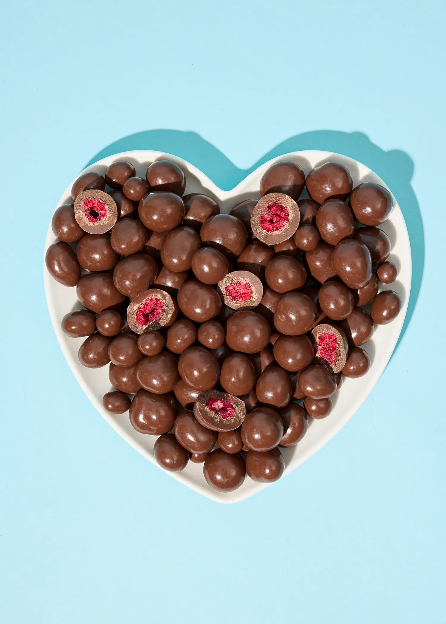 a heart shaped plate filled with chocolate covered berries