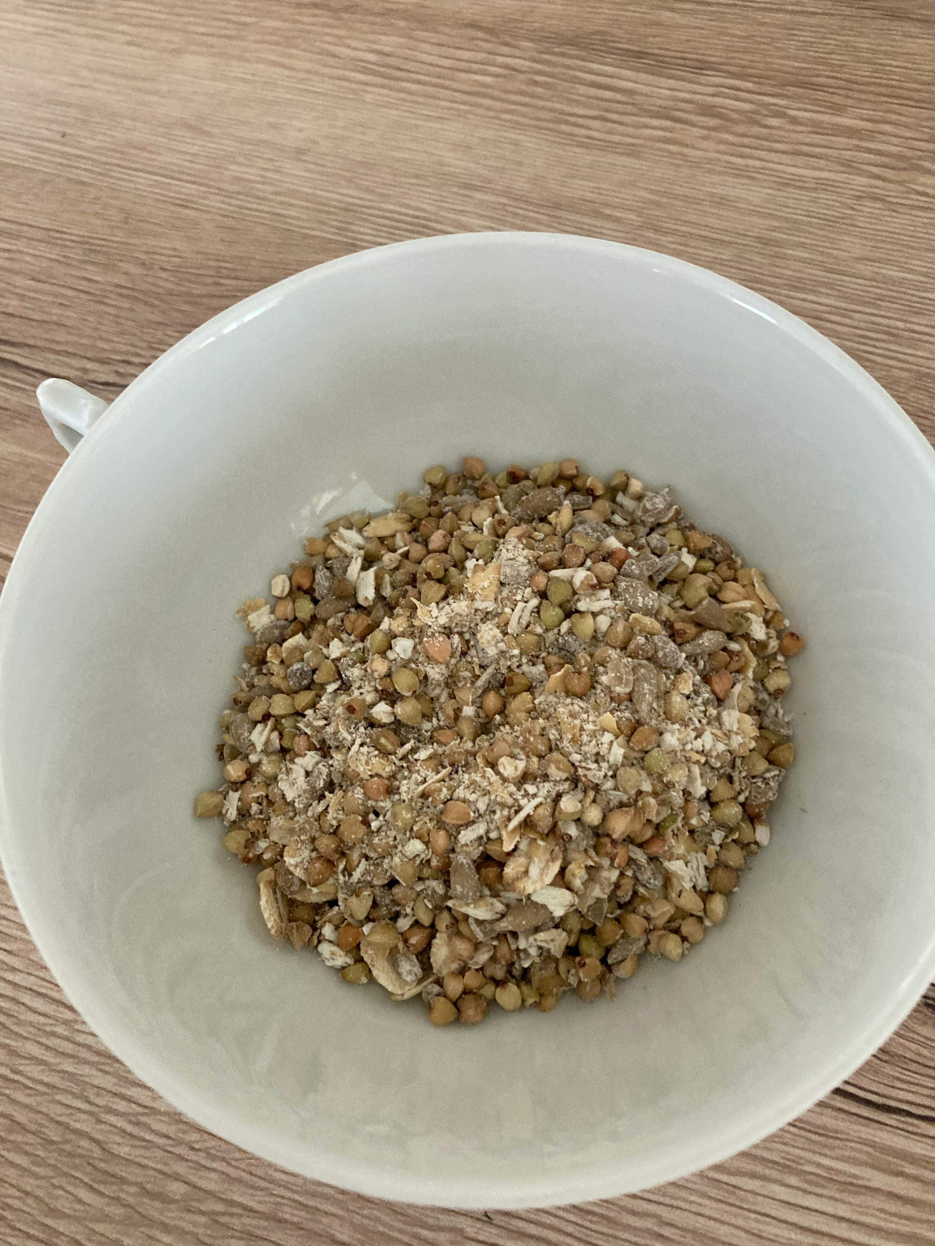 eine weiße Schüssel füllt sich mit verschiedenen Arten von Getreide