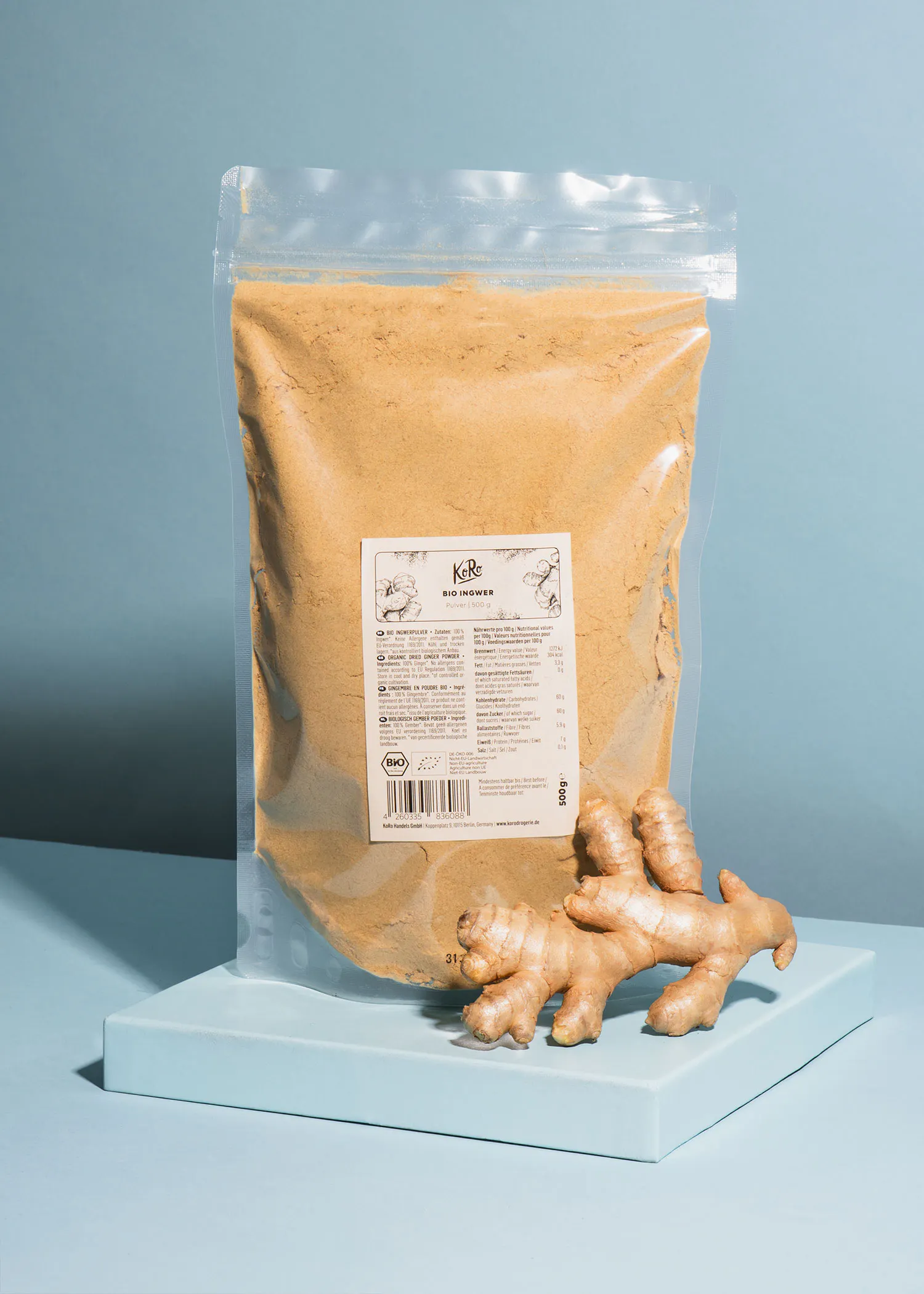 un sac de poudre de gingembre est assis à côté d' une racine de gingembre