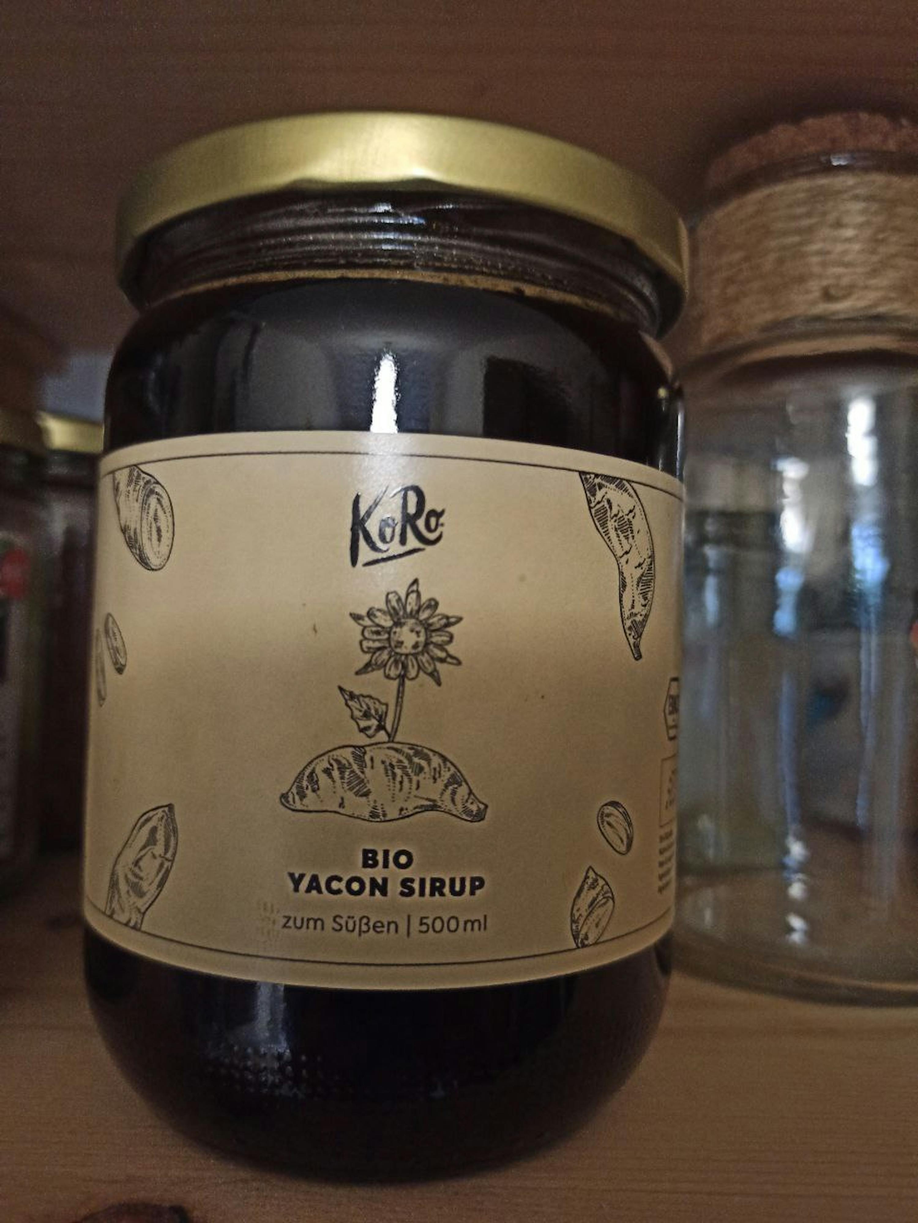 un bocal de sirop de yacon bio avec une fleur sur l' étiquette