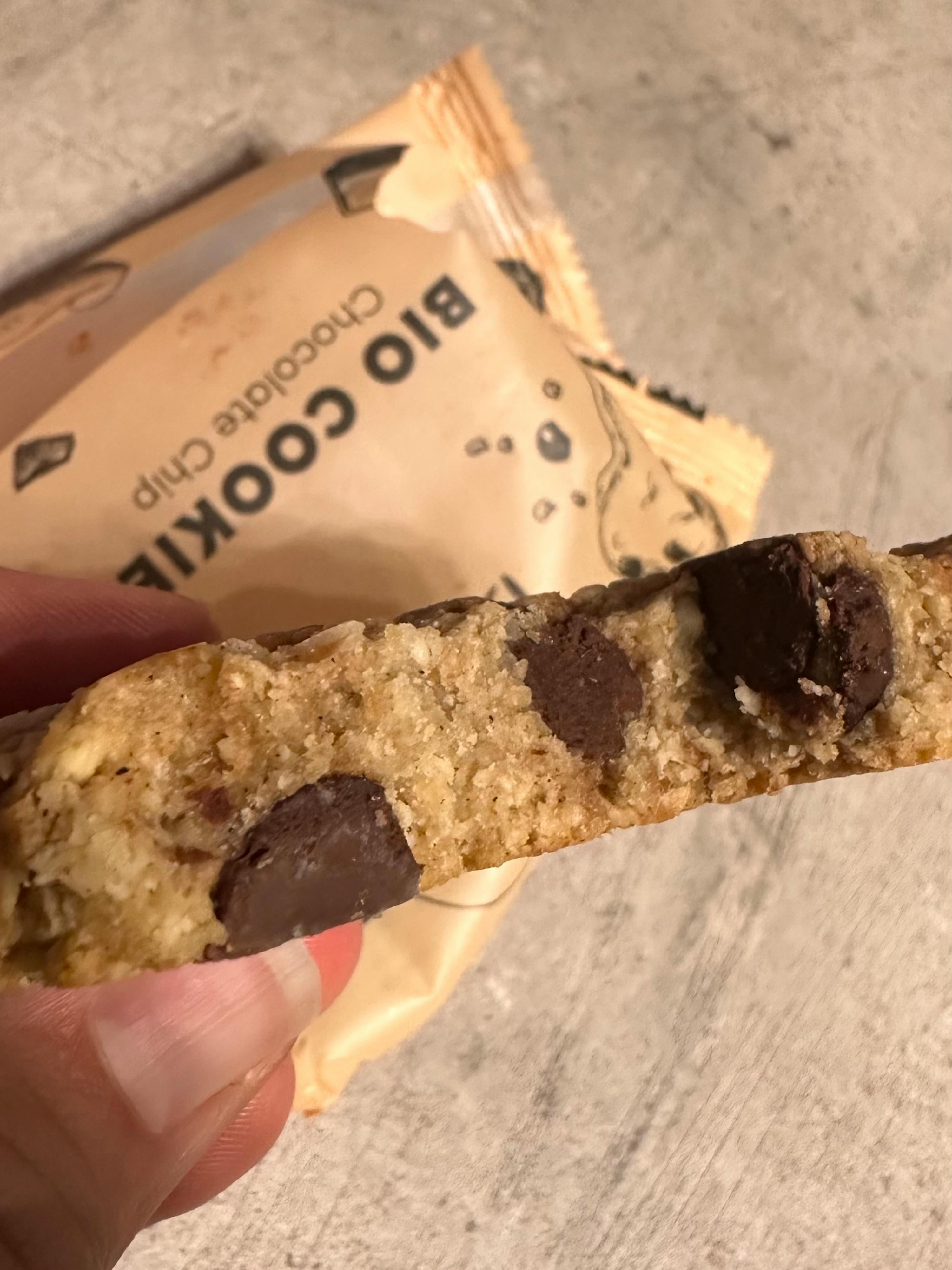Eine Person hält ein Bio-Schokoladenchip-Keks in der Hand