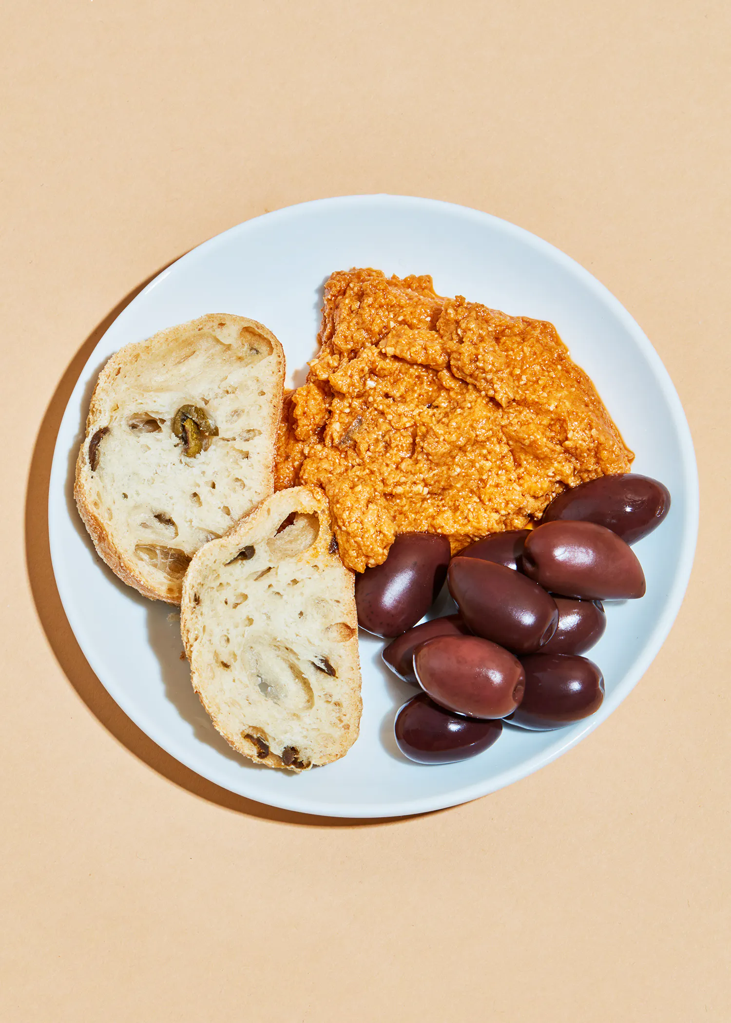 une assiette blanche avec du pain et des olives