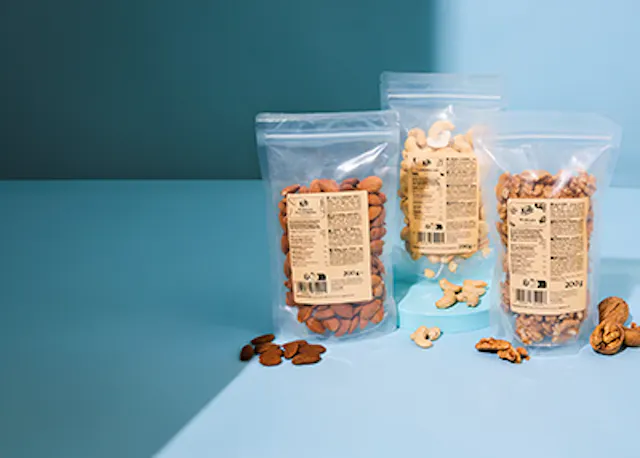 trois sacs de noix sont assis sur une table bleue