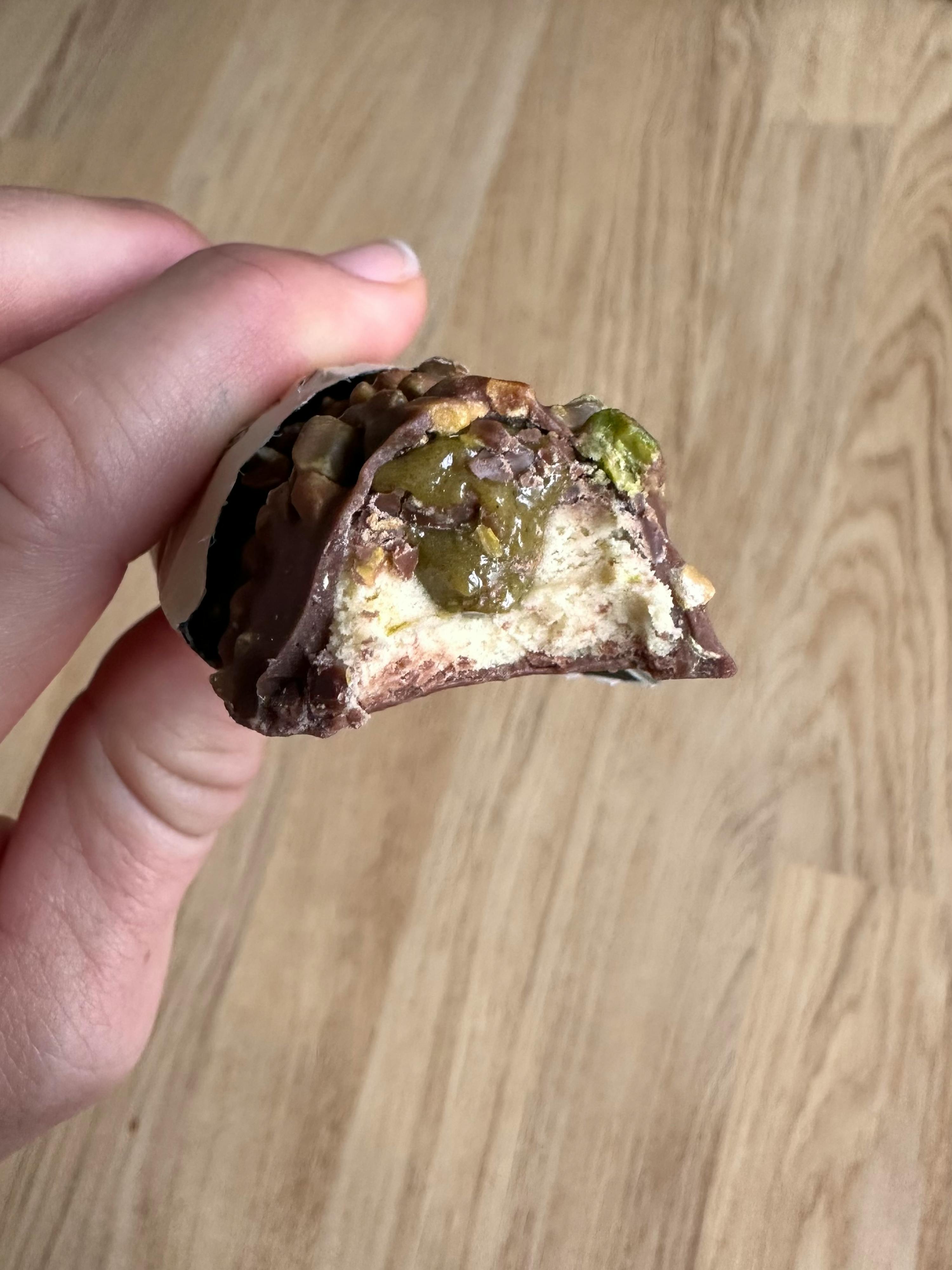 eine Person hält einen Schokoladenriegel mit pistazien in der Hand