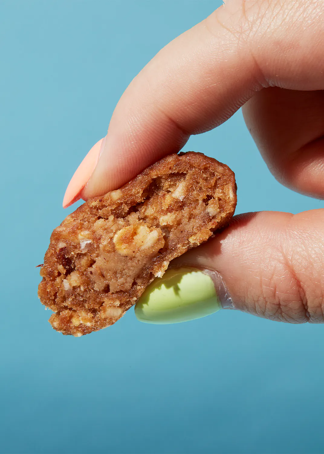 a person with green nails is holding a piece of food