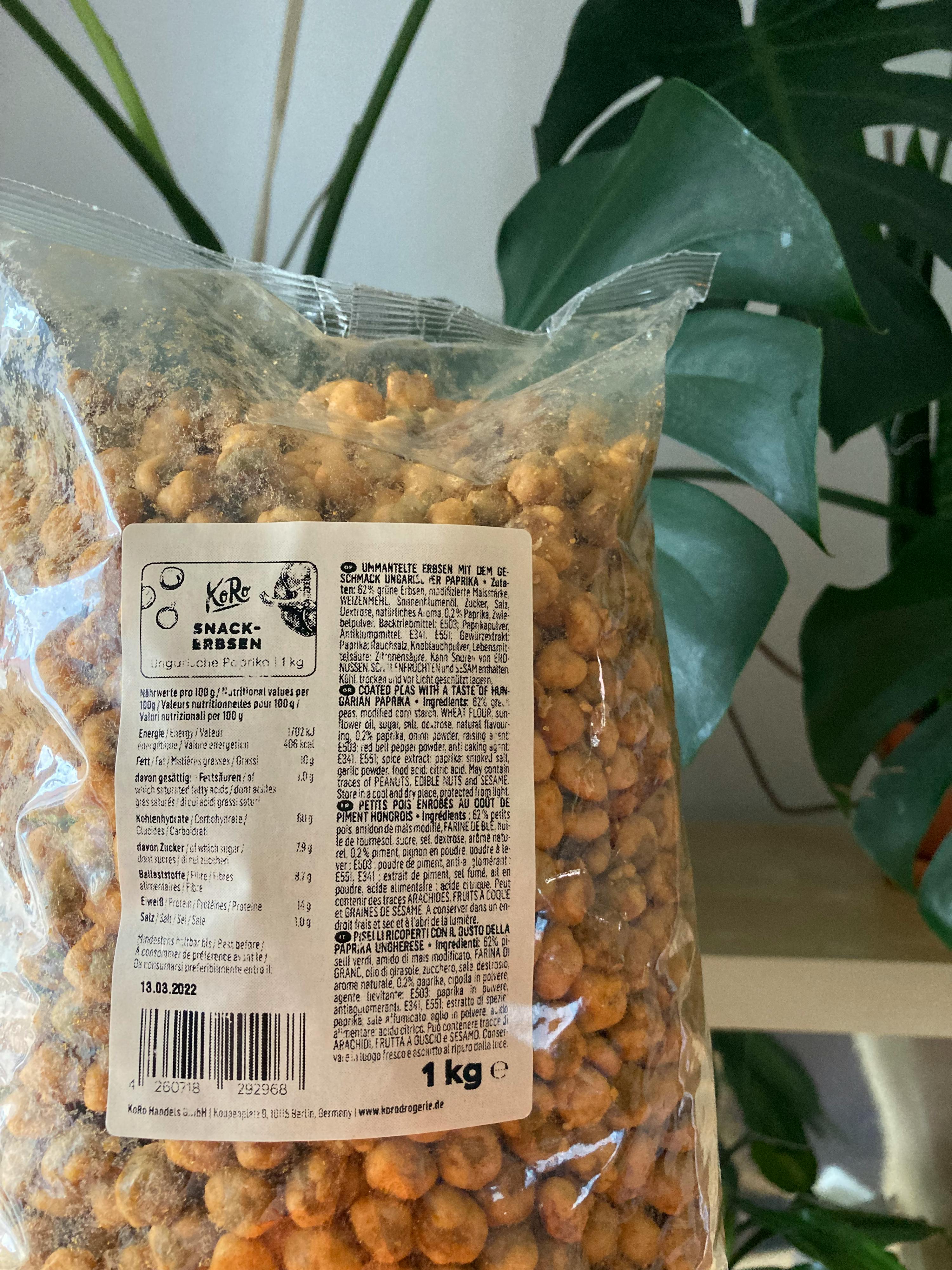 un sacchetto di arachidi è seduto su un tavolo accanto a una pianta