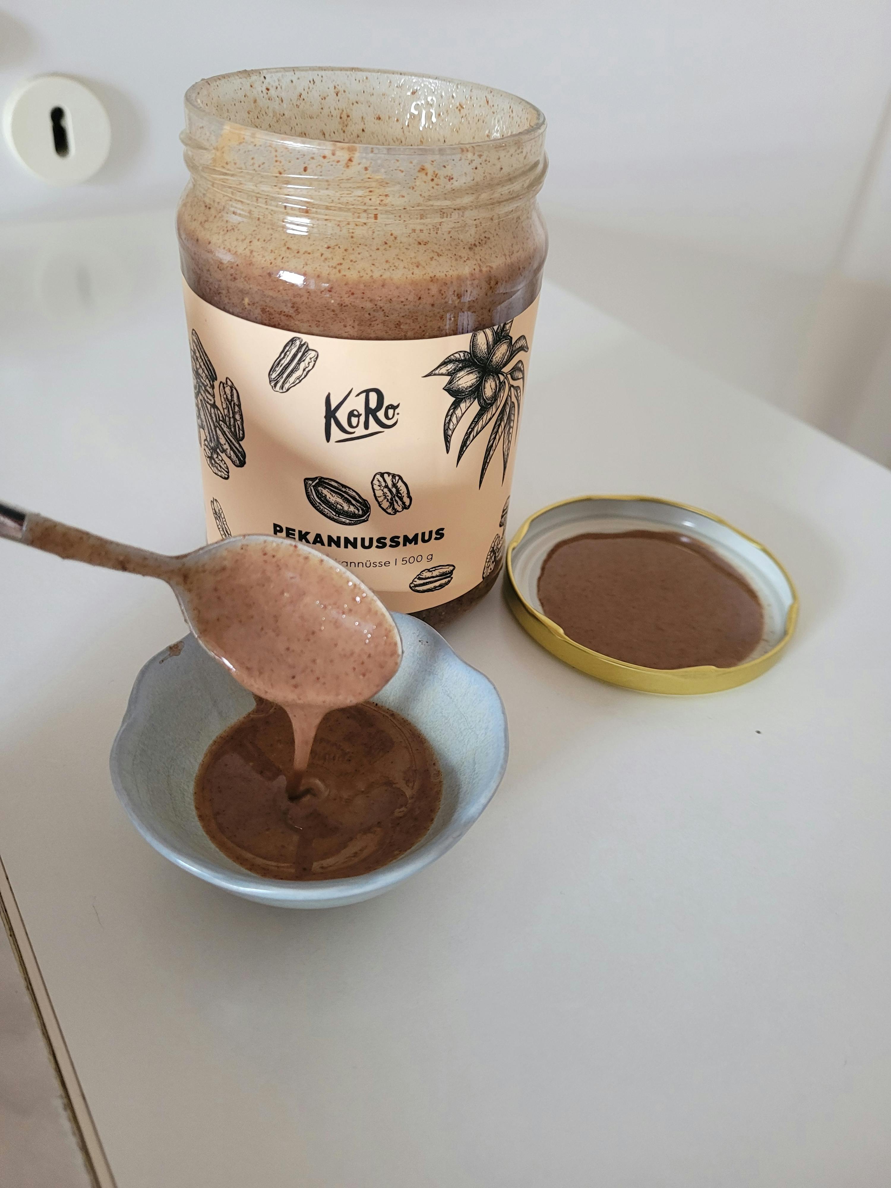 une cuillère est versée dans un bol de beurre de cacahuète