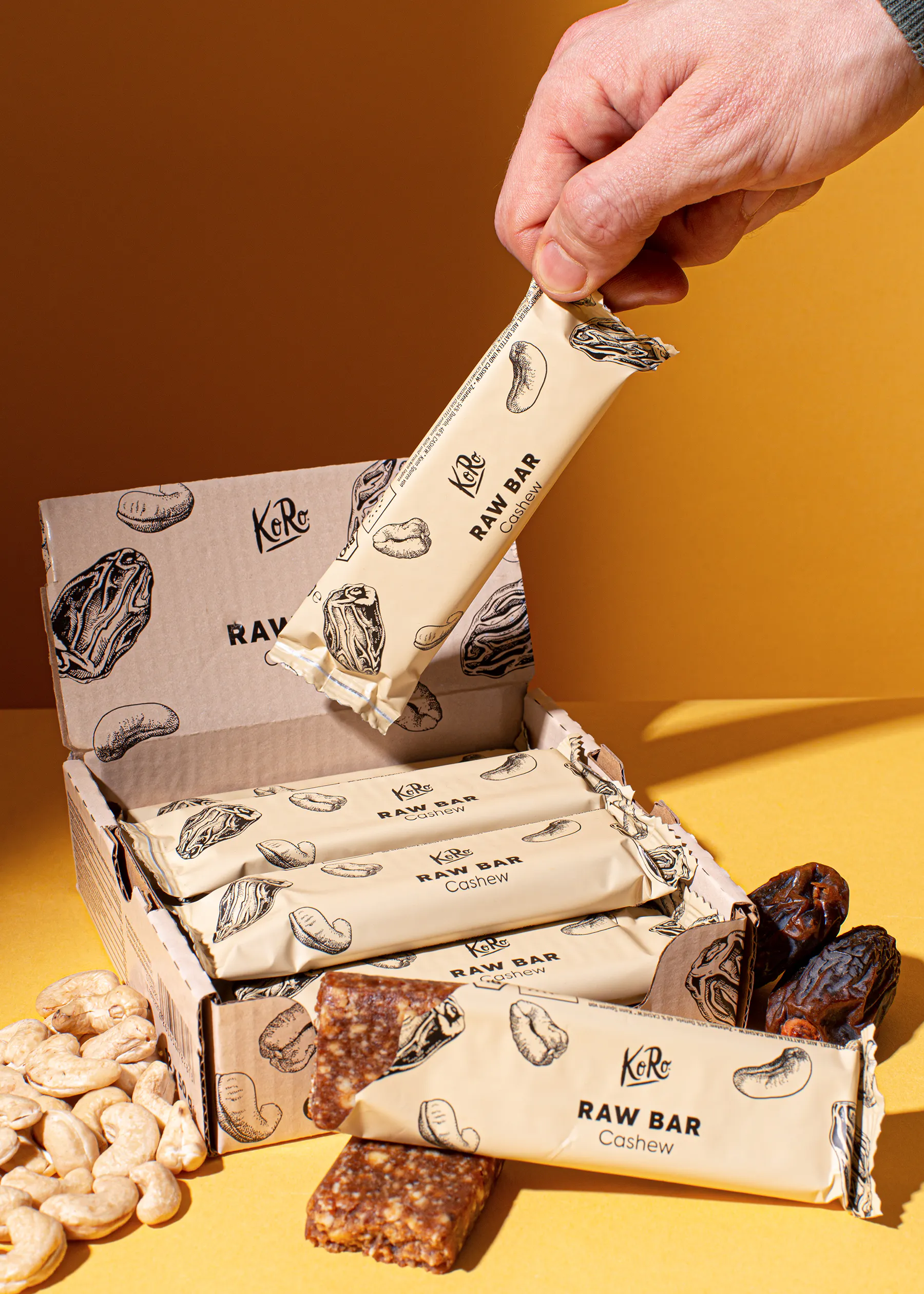 une personne tient une barre de raw cashew à l' intérieur d' une boîte