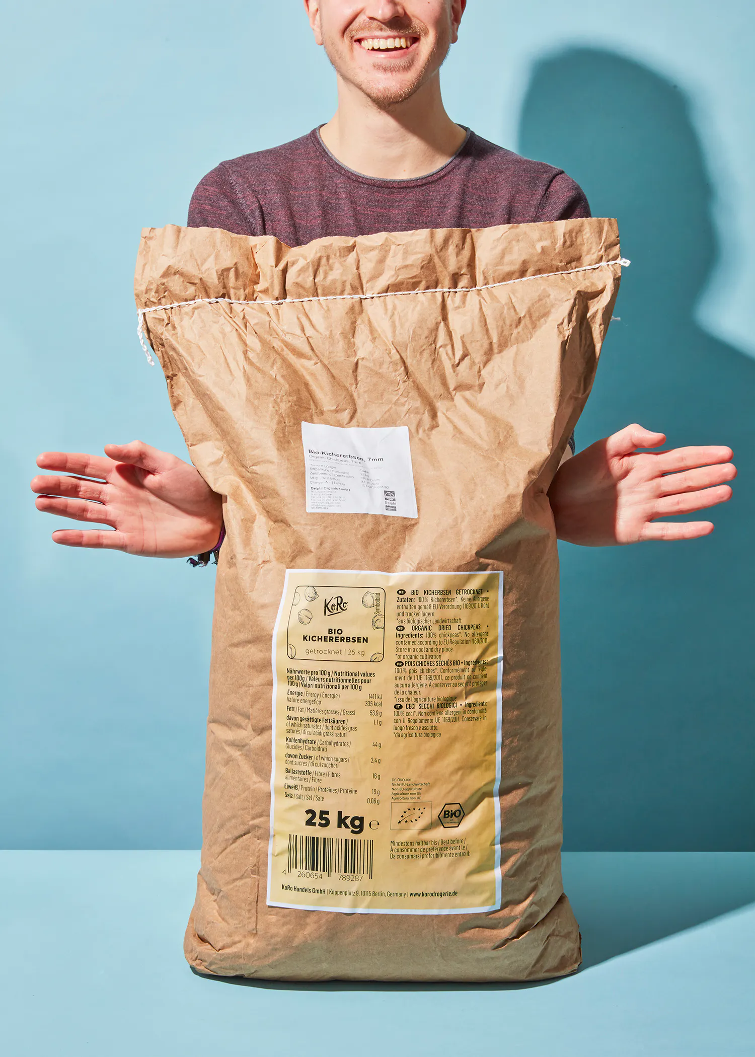 a man is holding a bag that says 25 kg