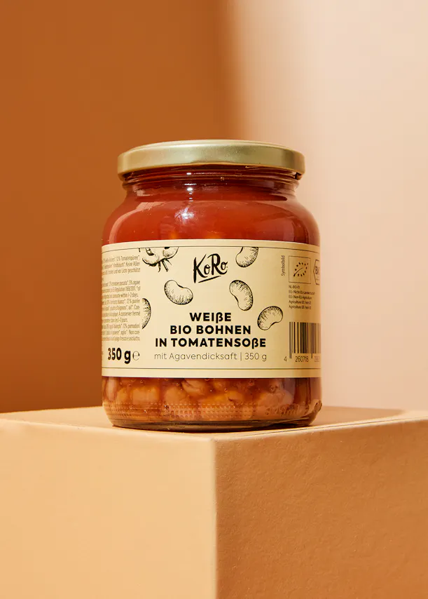 un bocal de haricots blancs dans une sauce tomate avec l' étiquette koro