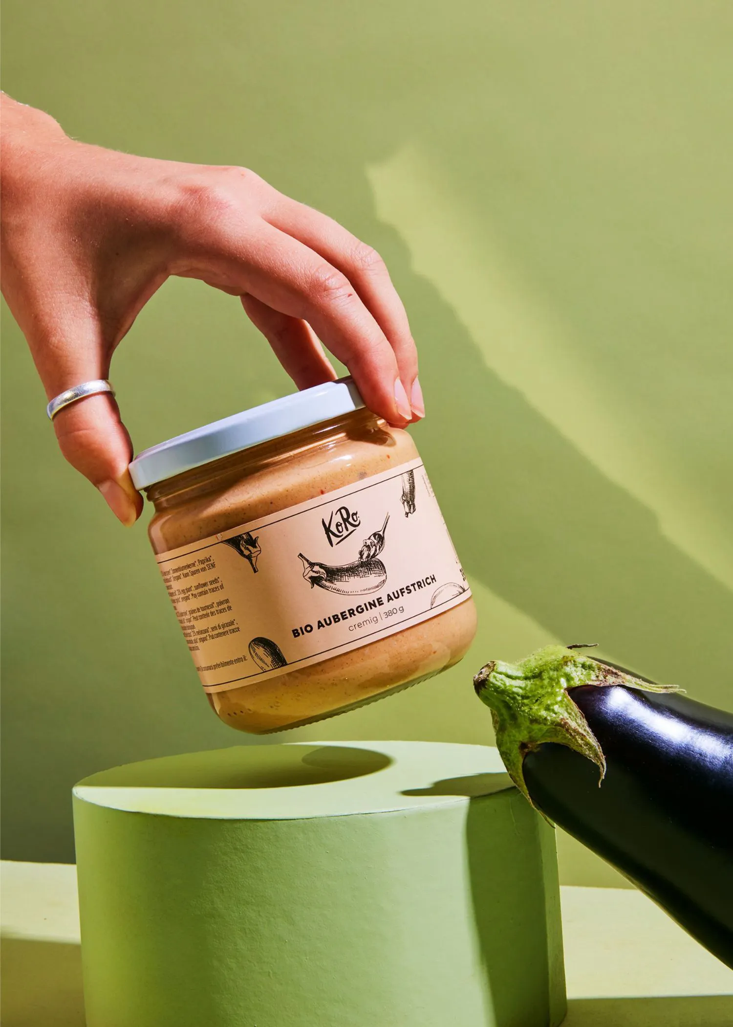 eine Person hält ein Glas mit der Aufschrift " bio aubergine aufstrich "