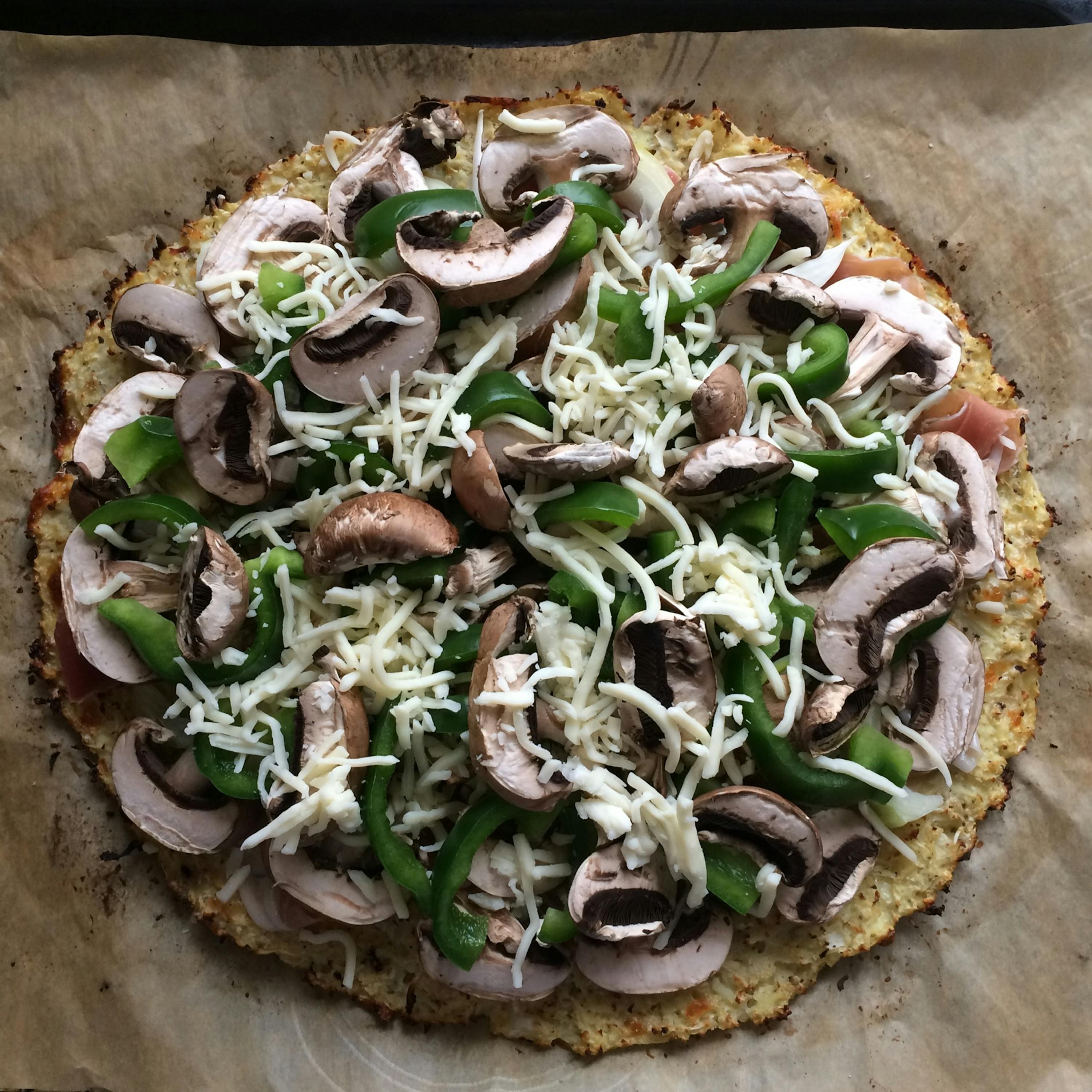un primo piano di una pizza con funghi e peperoni