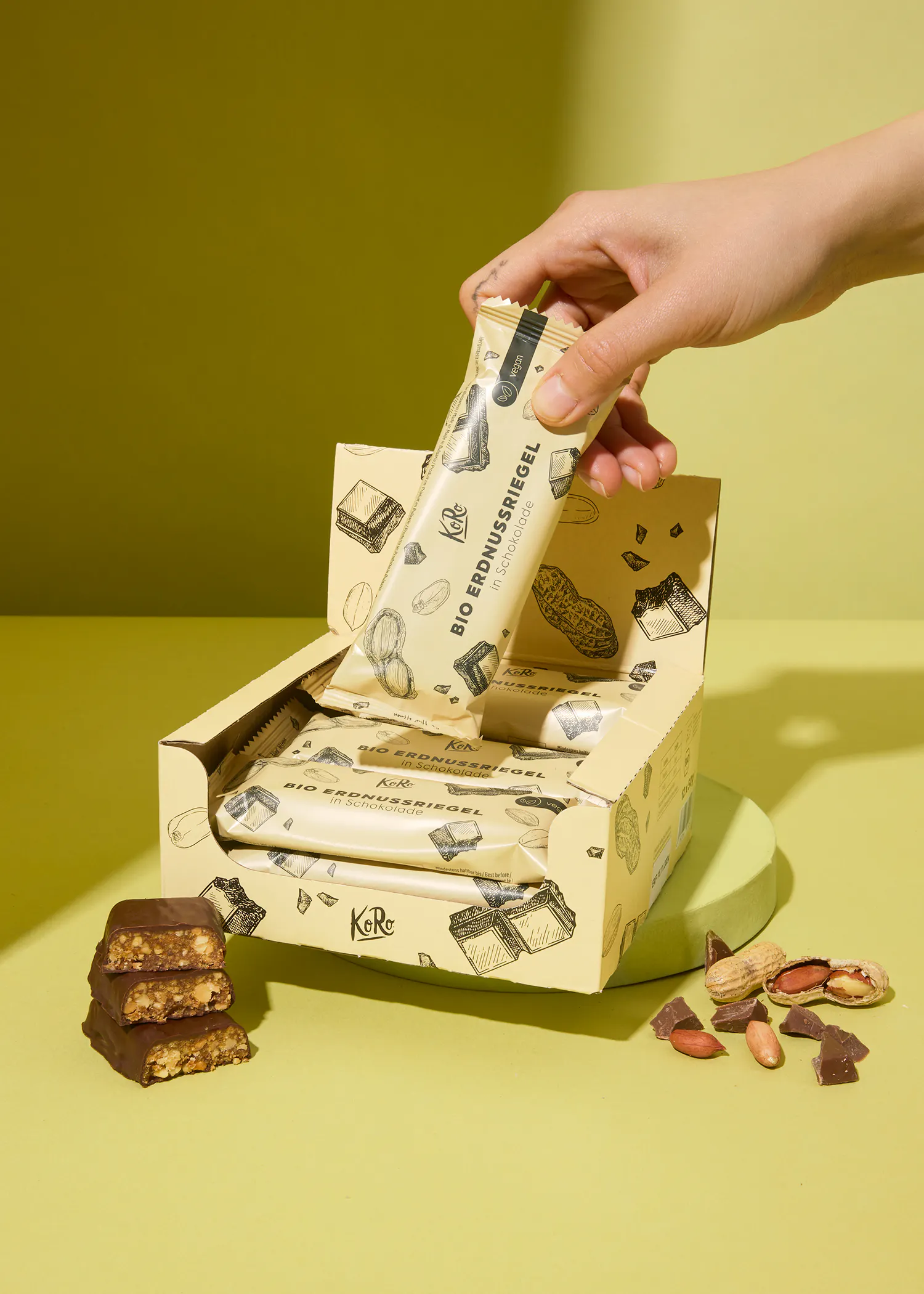 eine Person nimmt eine Erdnussriegel aus einer Schachtel