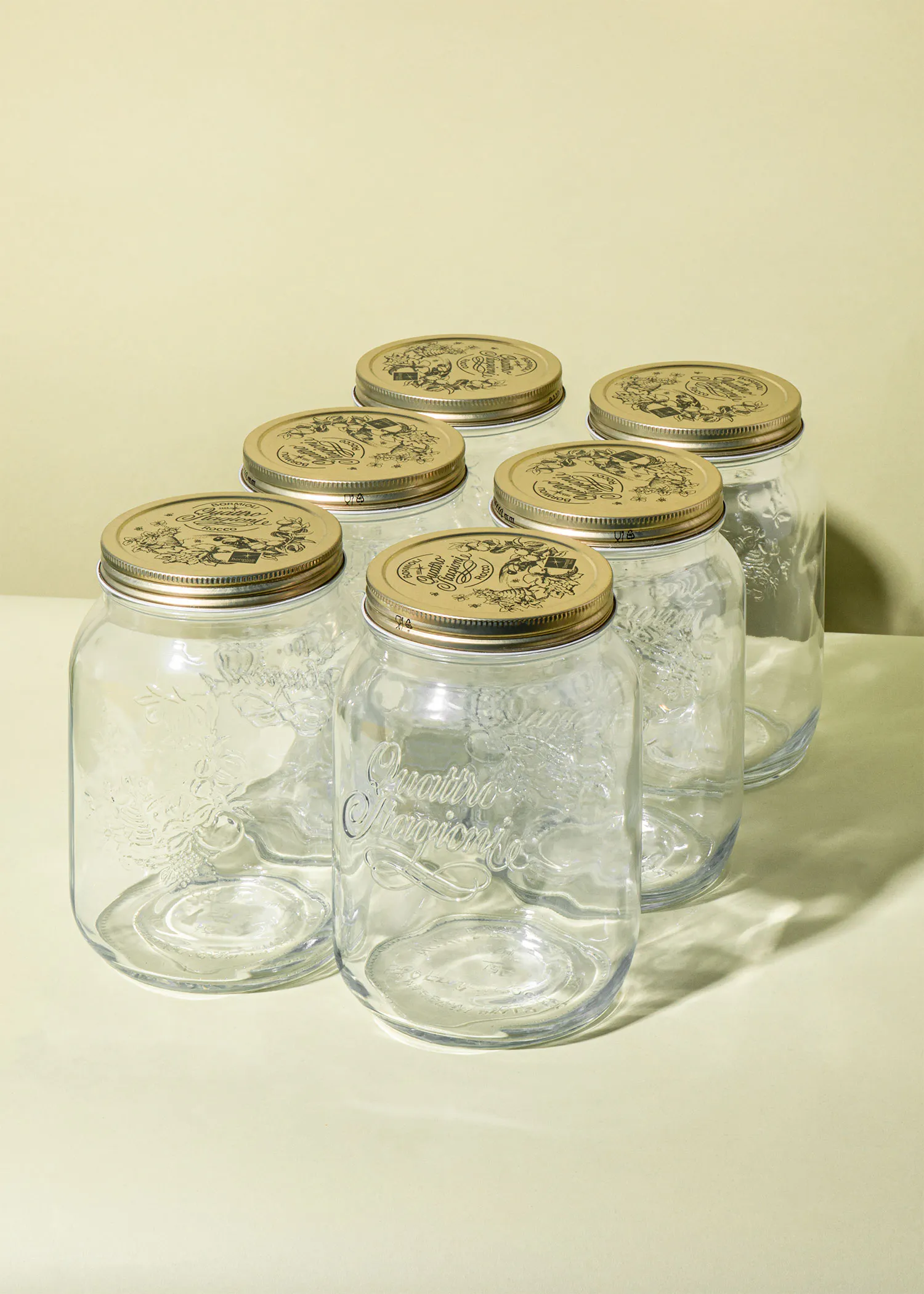 six glass jars with gold lids that say quattro stagioni