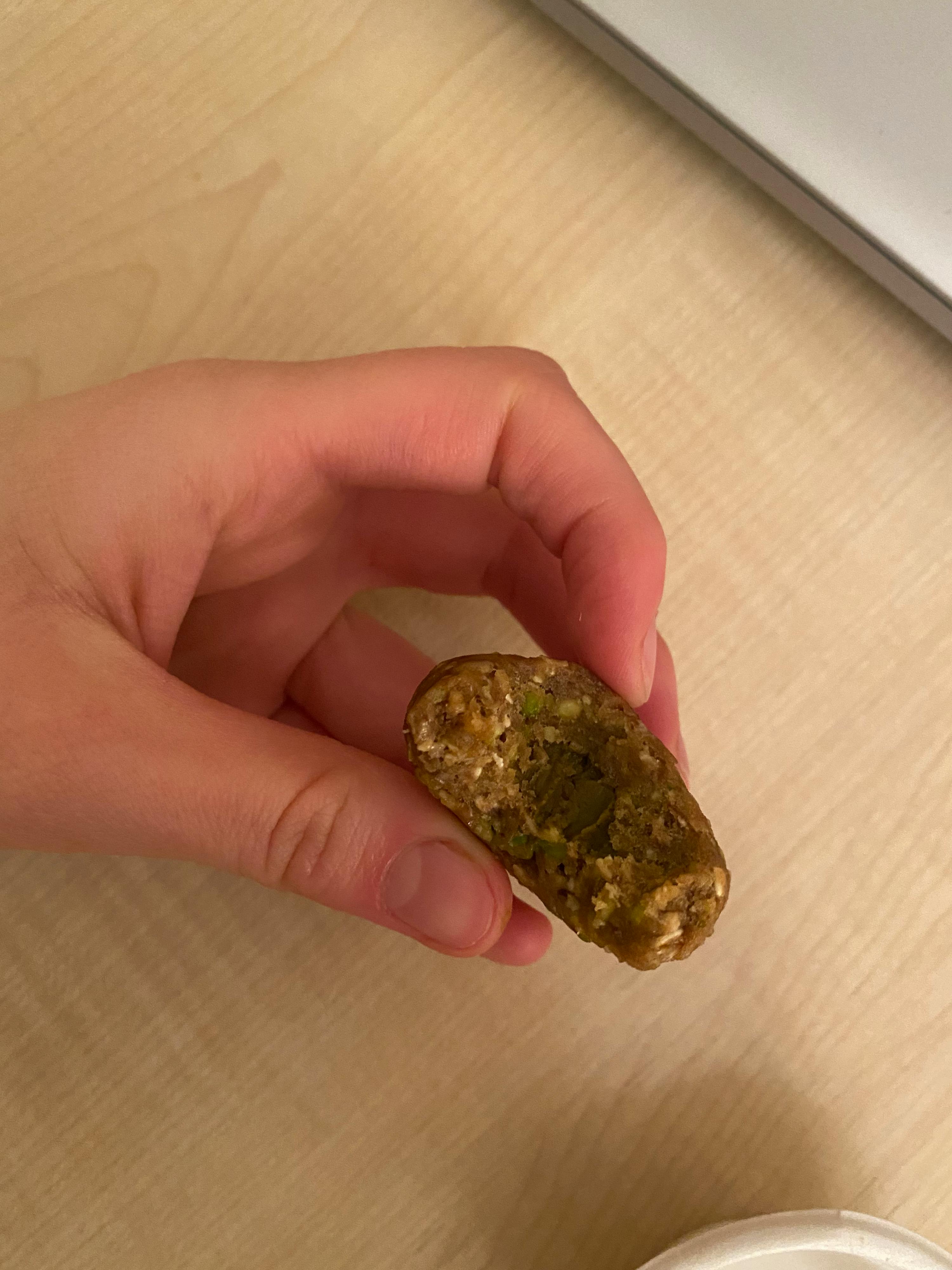 eine Person hält ein Stück Essen mit einem Stück herausgenommen