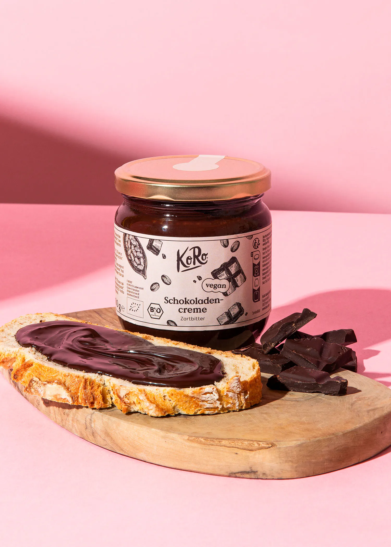 une bouteille de crème au chocolat avec une tranche de pain sur une planche à découper en bois