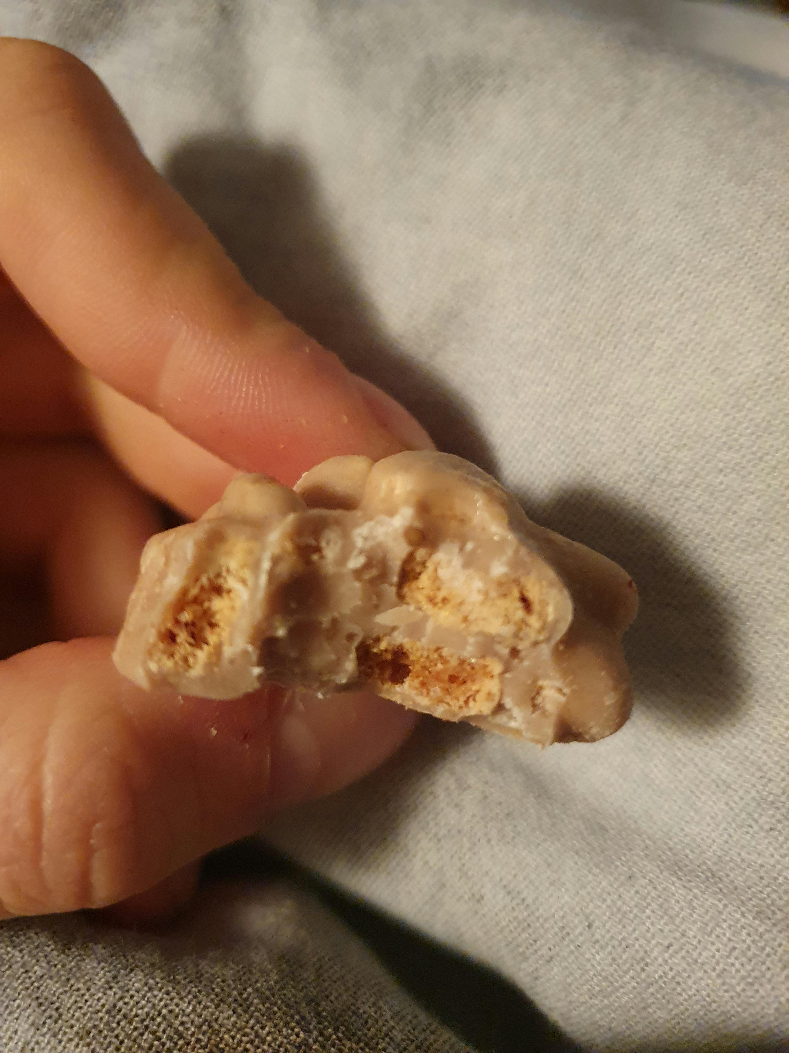 un gros plan d' une personne tenant un morceau de nougat