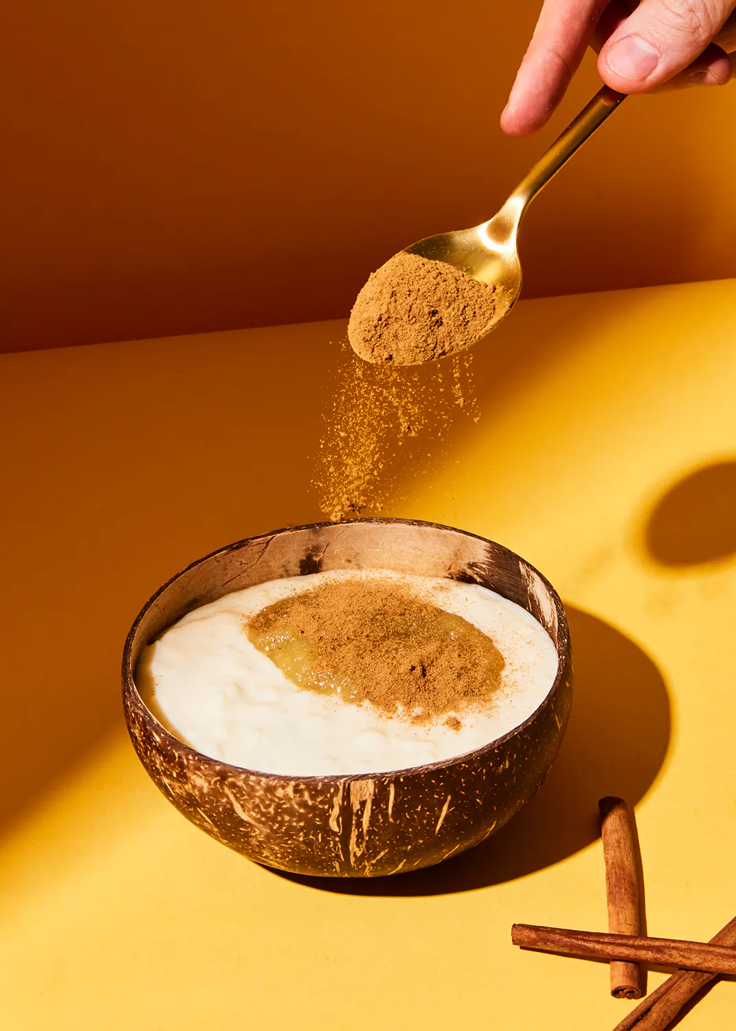 a person is pouring cinnamon into a bowl of food