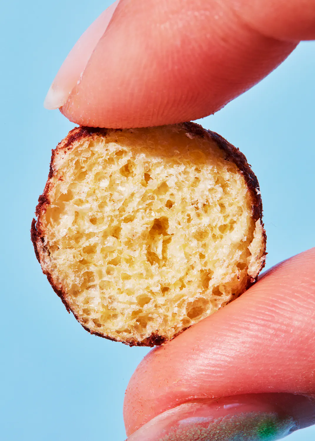 une personne tient un morceau de pain dans ses doigts