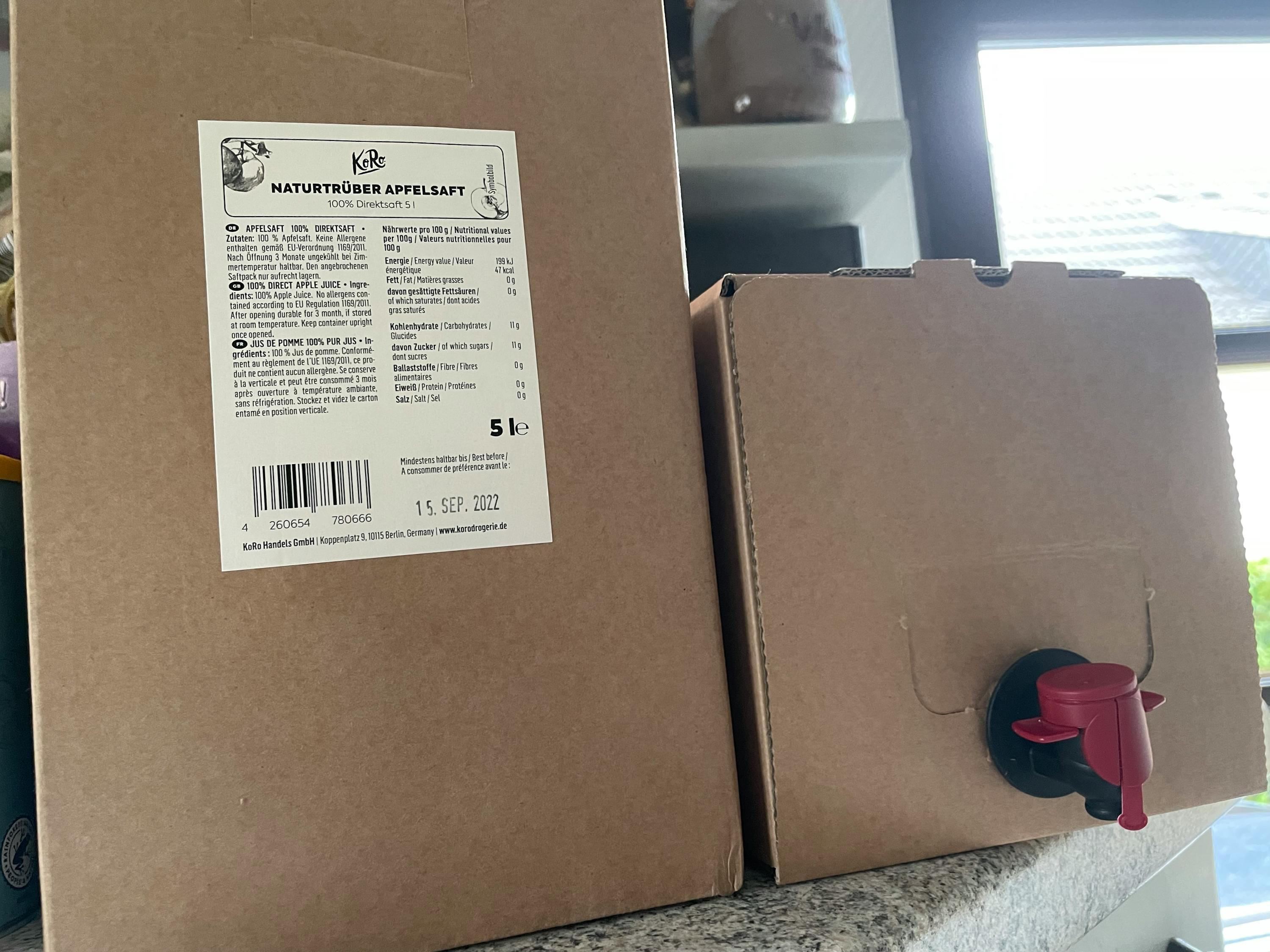 deux boîtes de jus de pomme sont assises sur une table