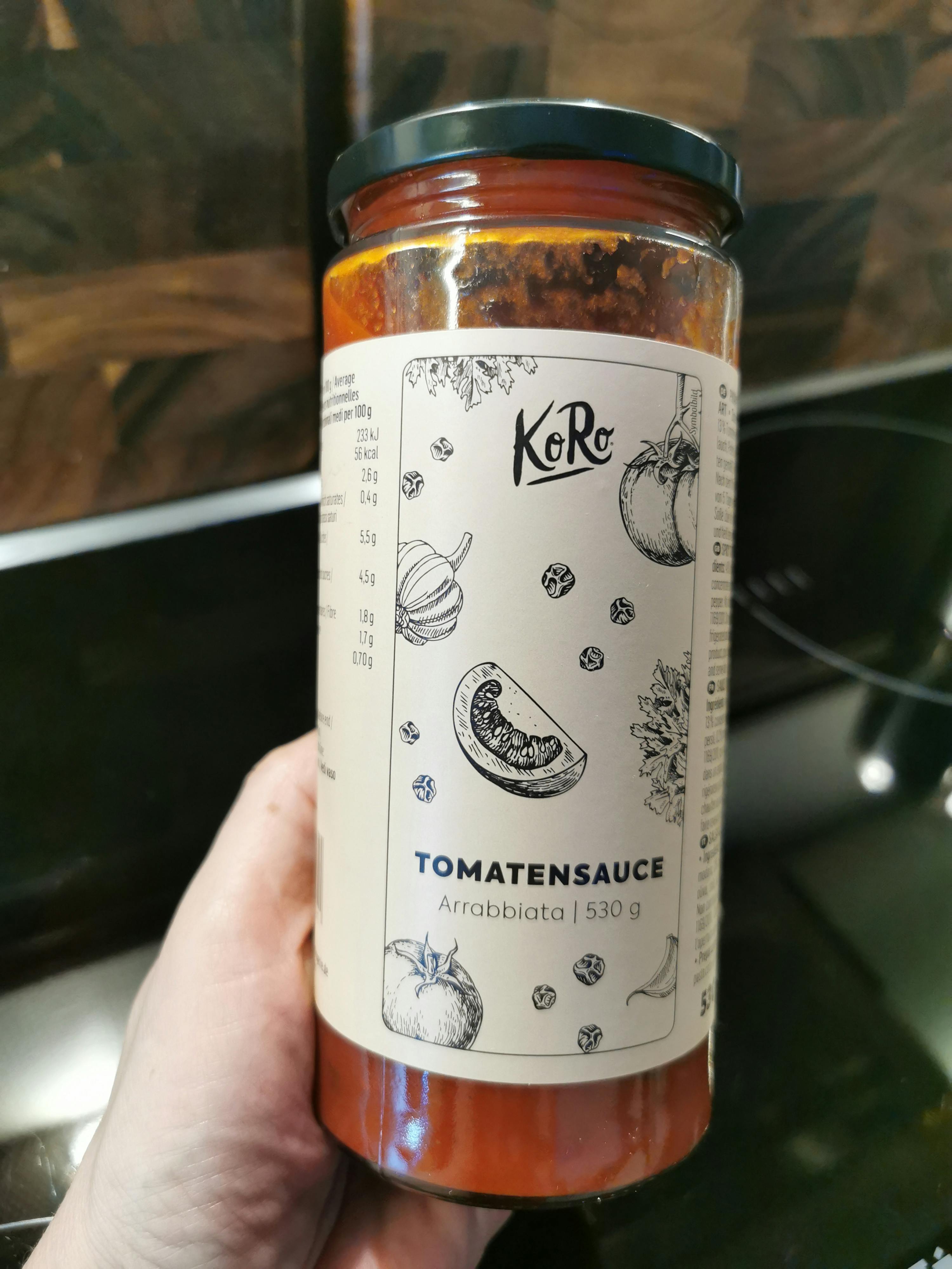 a person is holding a jar of tomato sauce with a white label