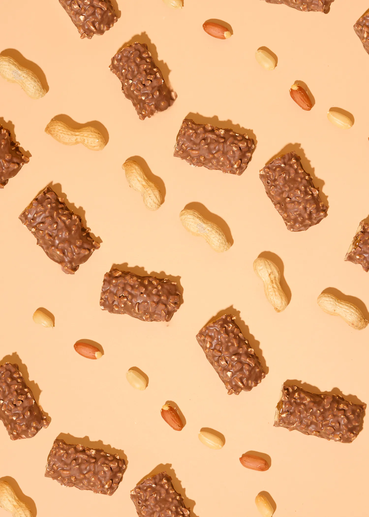 a pattern of chocolate bars and peanuts on an orange background