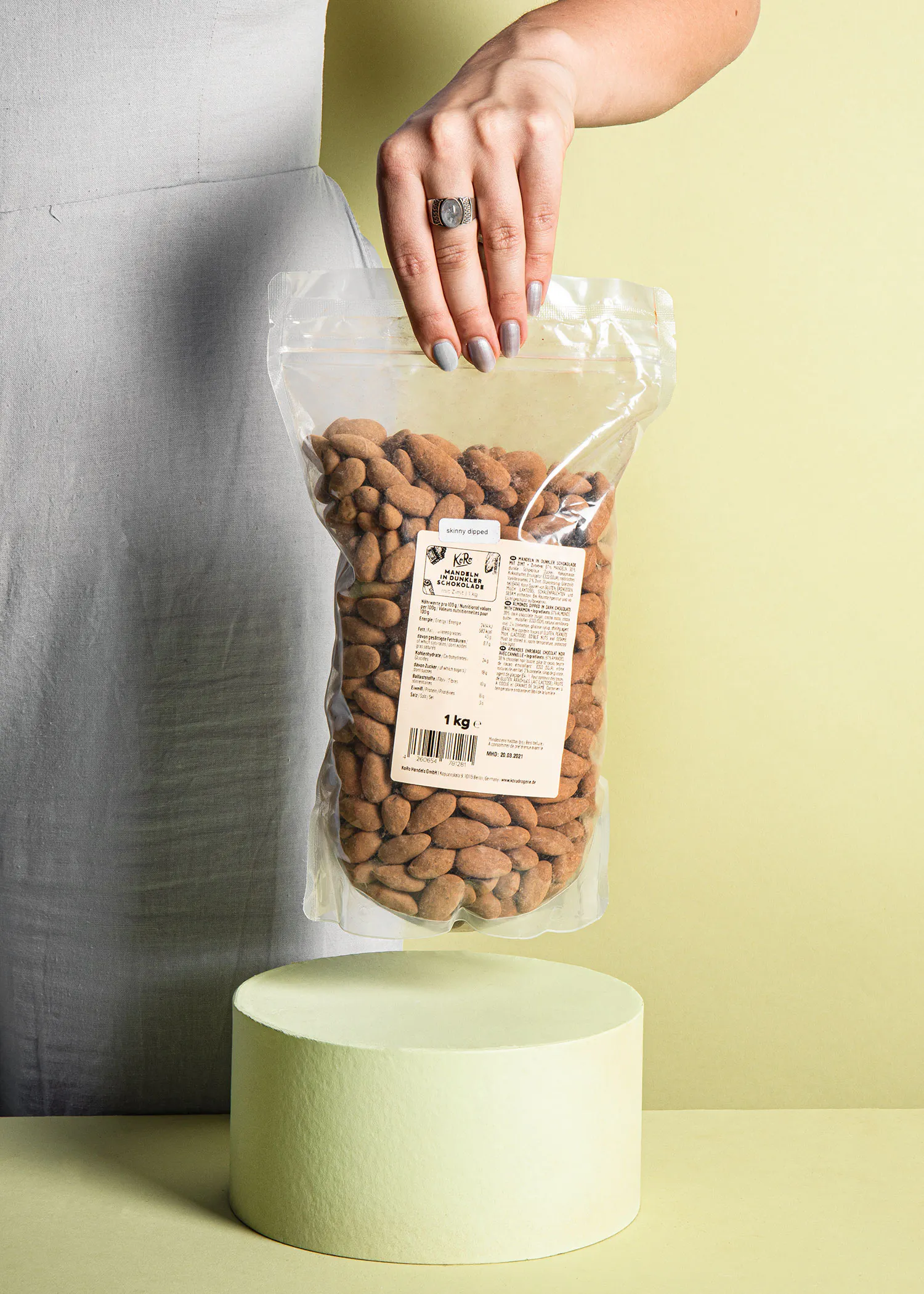 Eine Frau hält einen Plastikbeutel mit Mandeln in der Hand