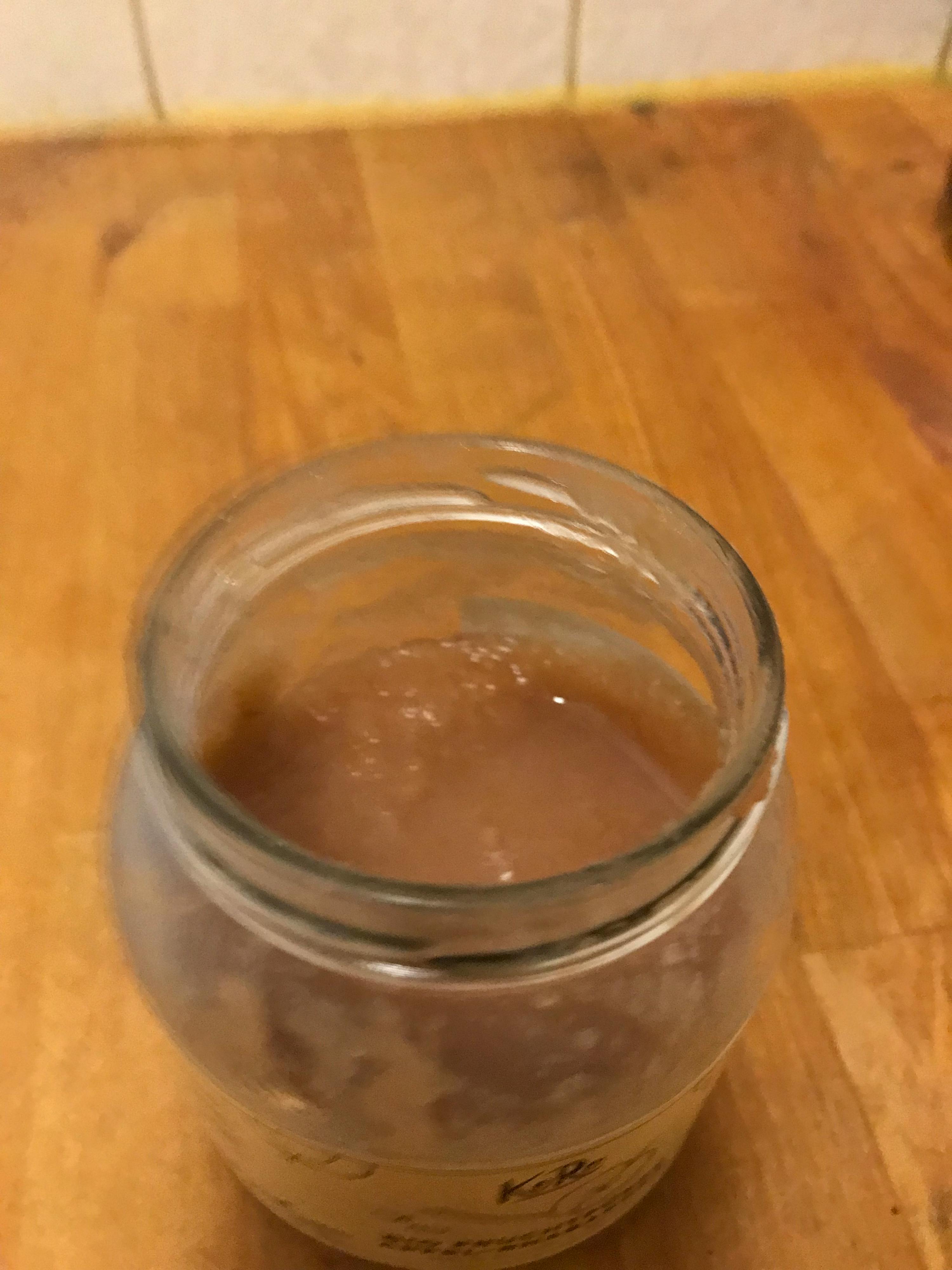 un bocal en verre rempli d' un liquide brun