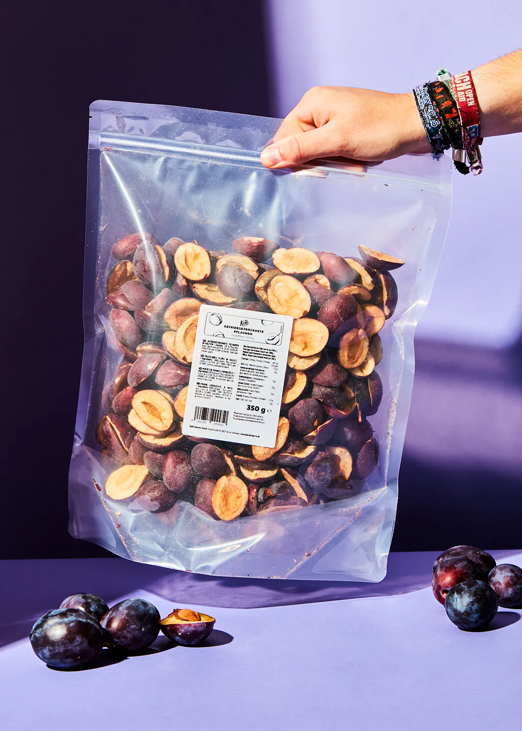 eine Person hält einen Plastikbeutel mit getrockneten Pflaumen in der Hand