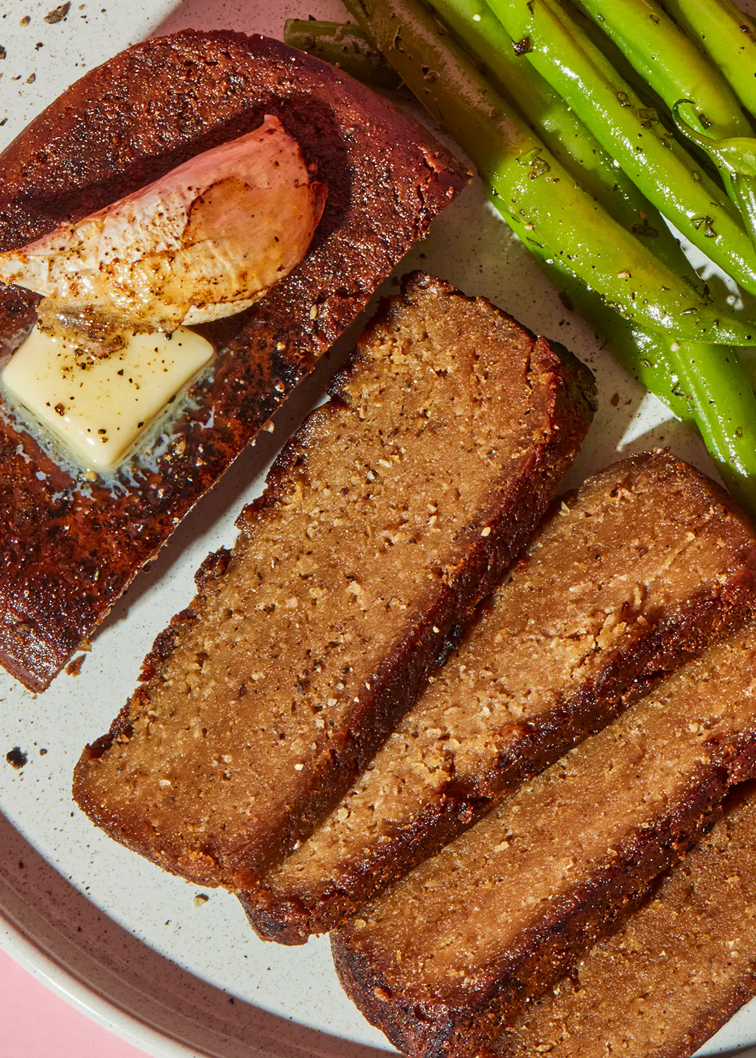 a white plate topped with meat loaf and asparagus