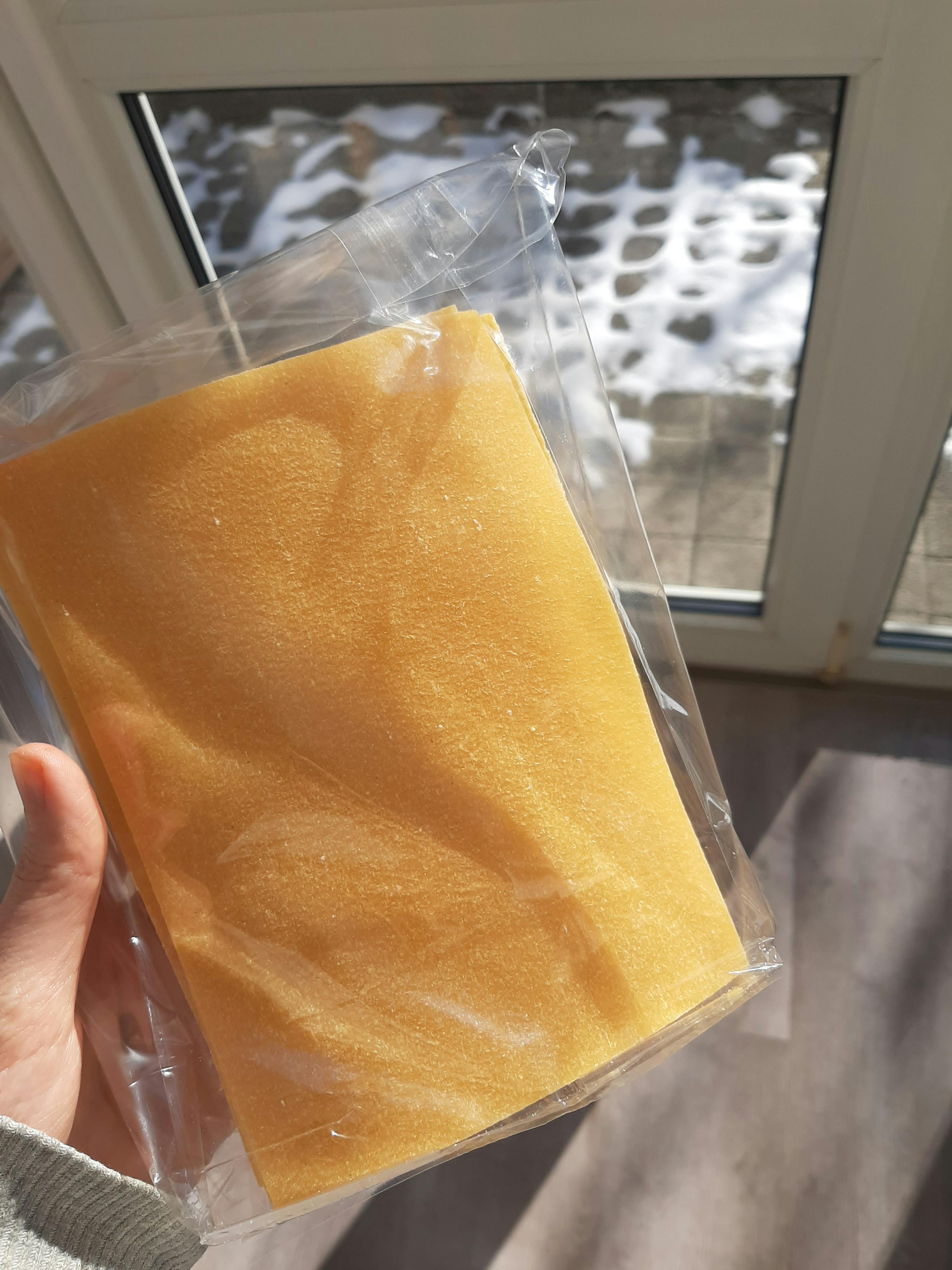 une personne tient une éponge jaune dans un sac en plastique