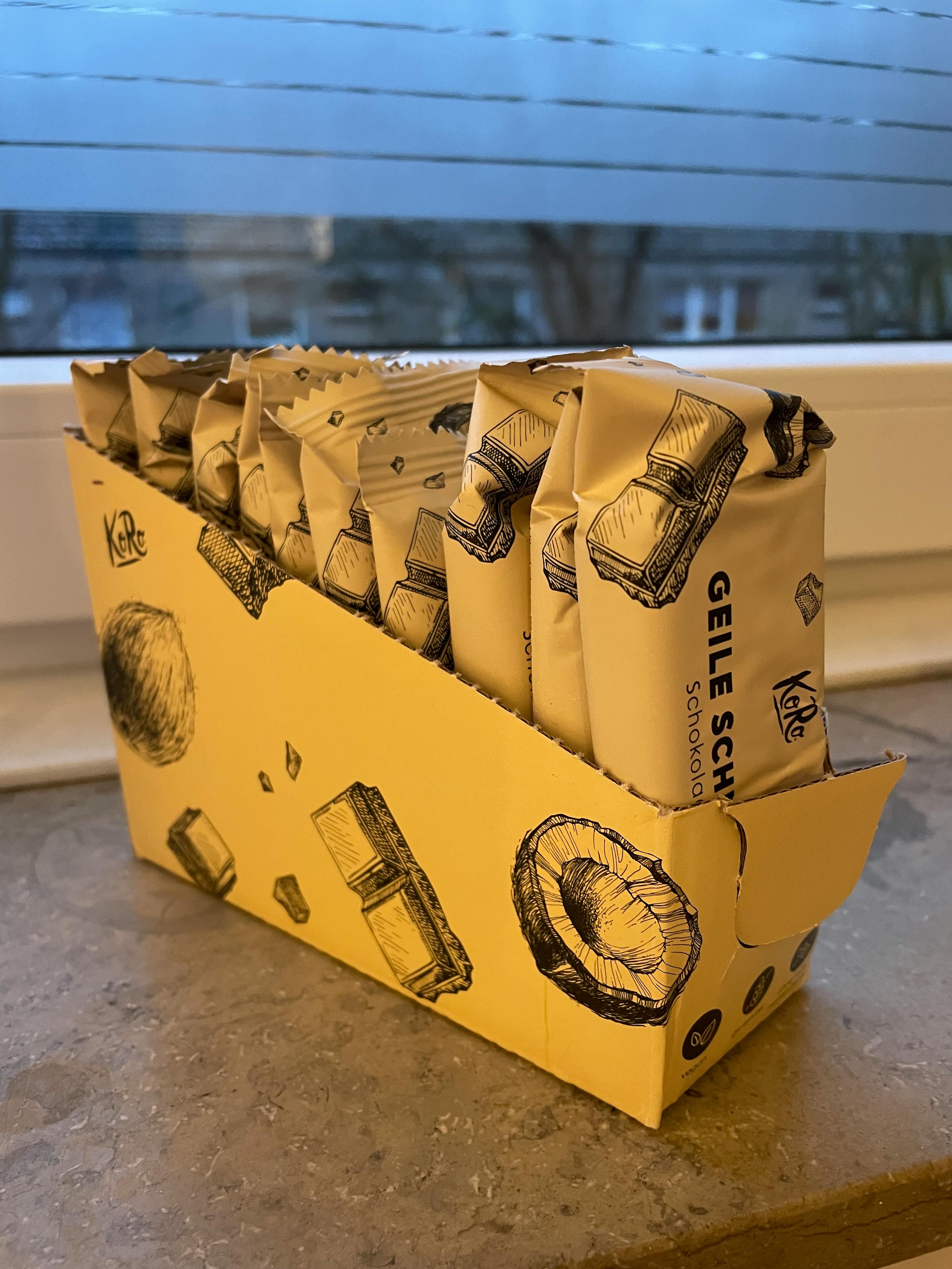a box of geile schokolade sits next to a window