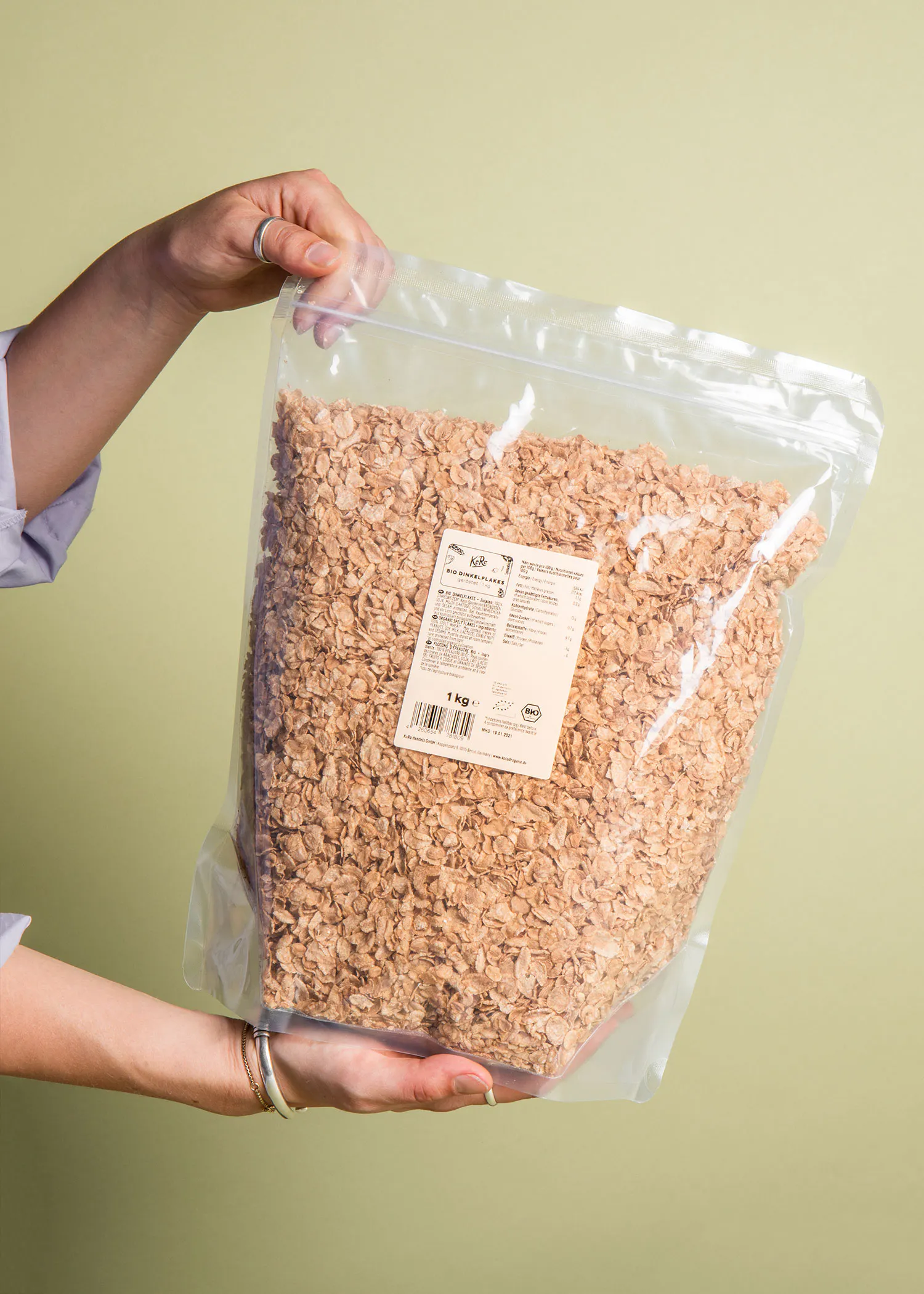 une personne tient un sac en plastique de flocons d' avoine