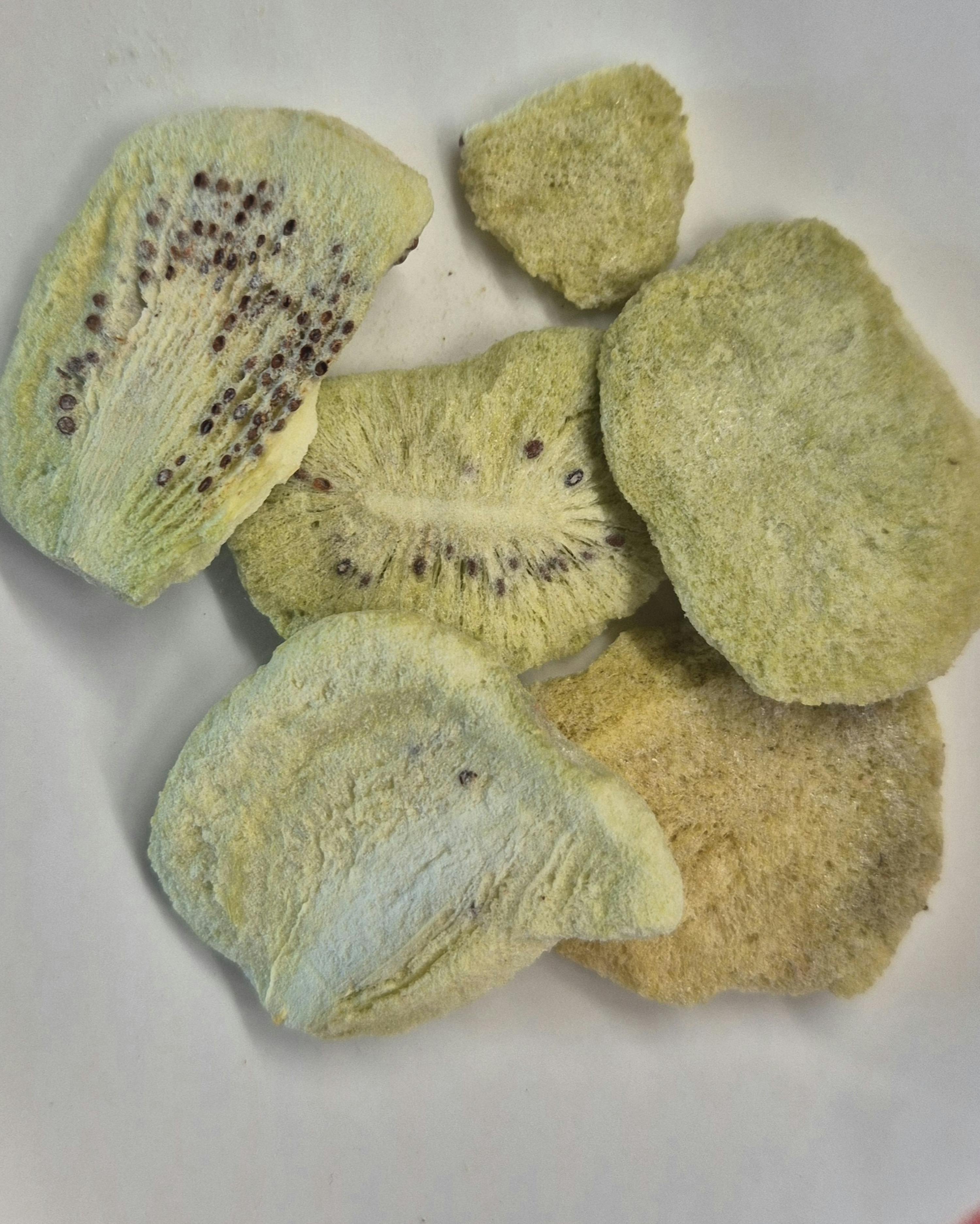 ein weißer Teller mit einem Haufen getrockneter Kiwis