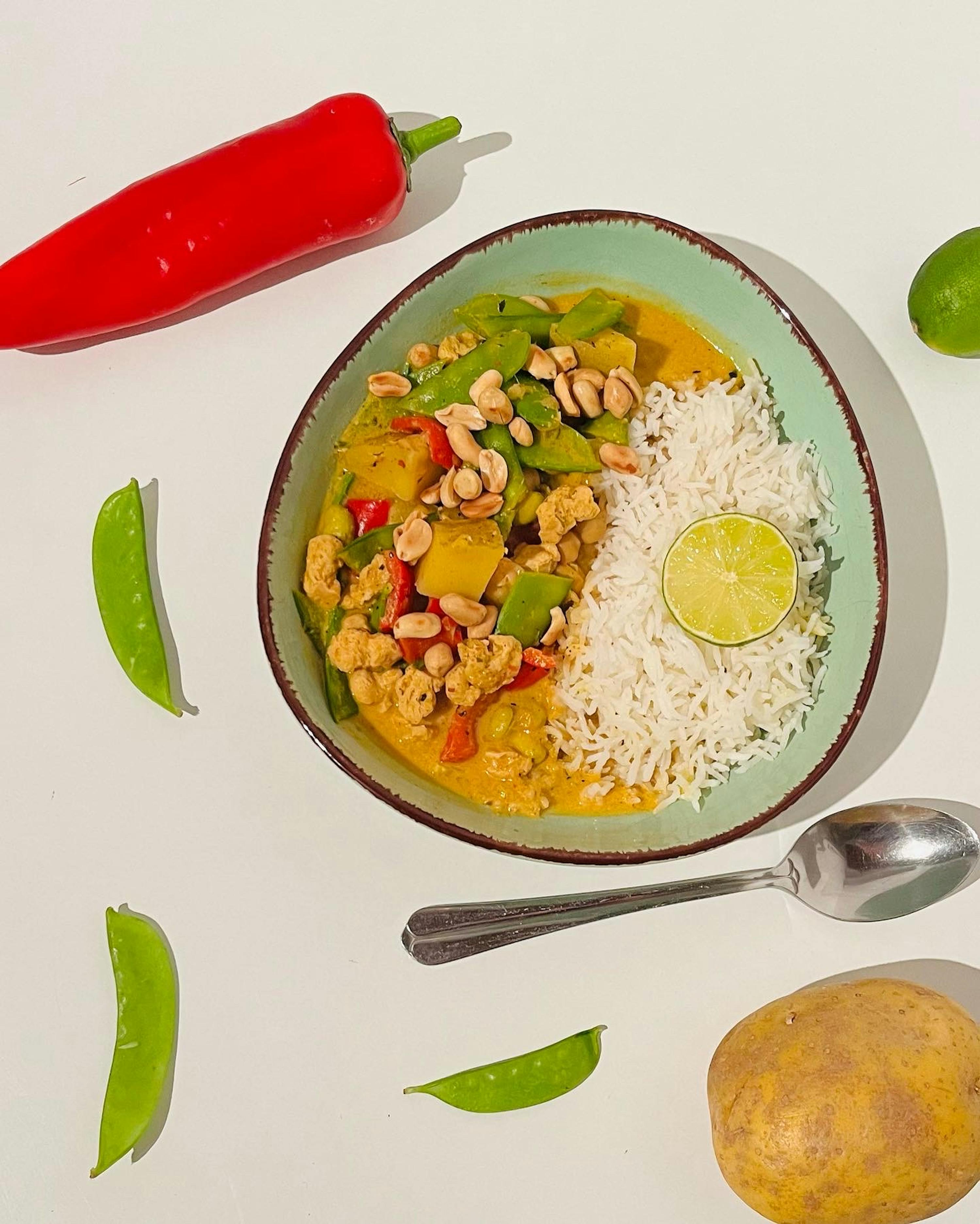 a bowl of food with rice and a lime wedge