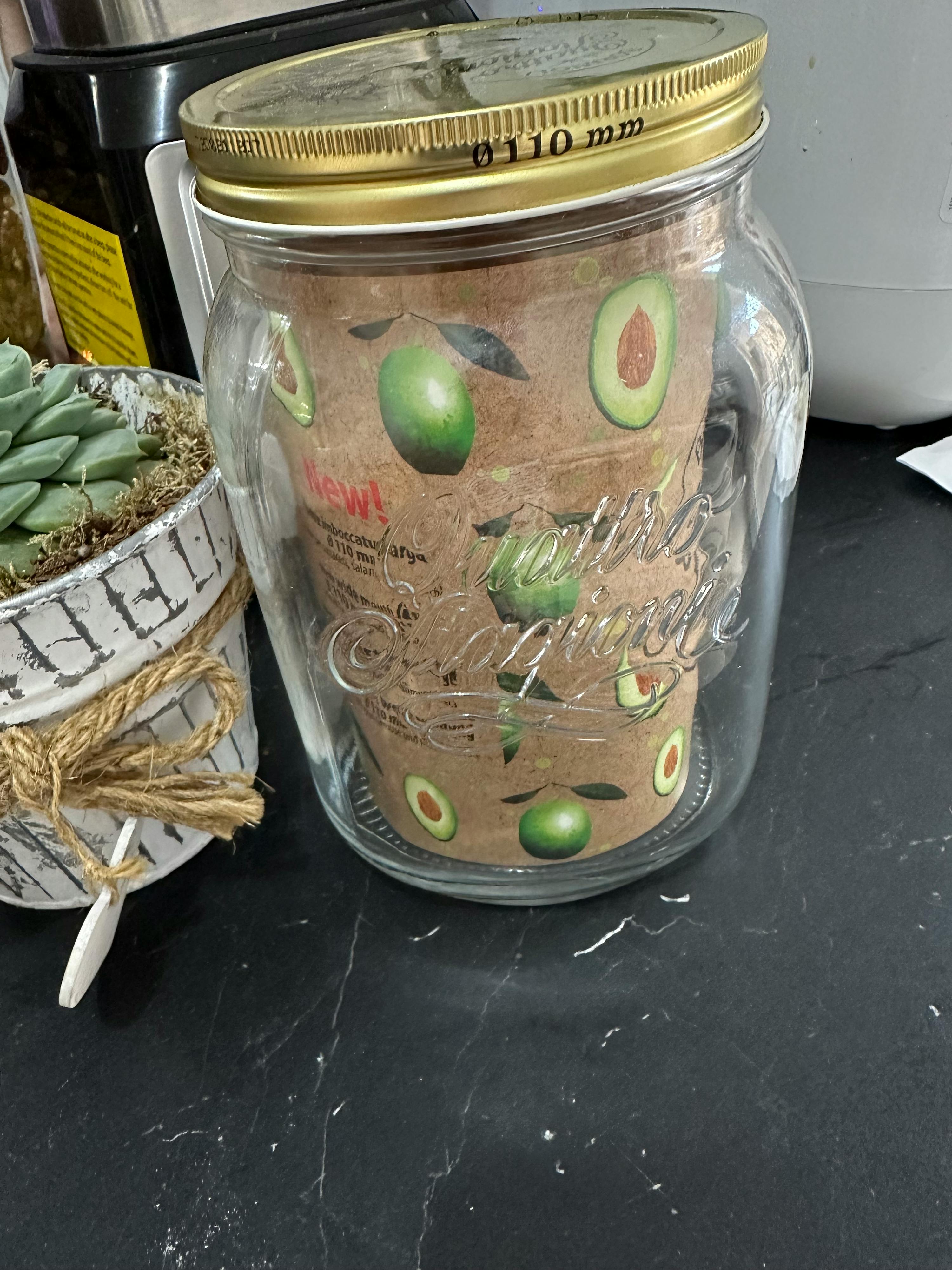 ein Glasgefäß mit einem Deckel und einem Avocadodesign