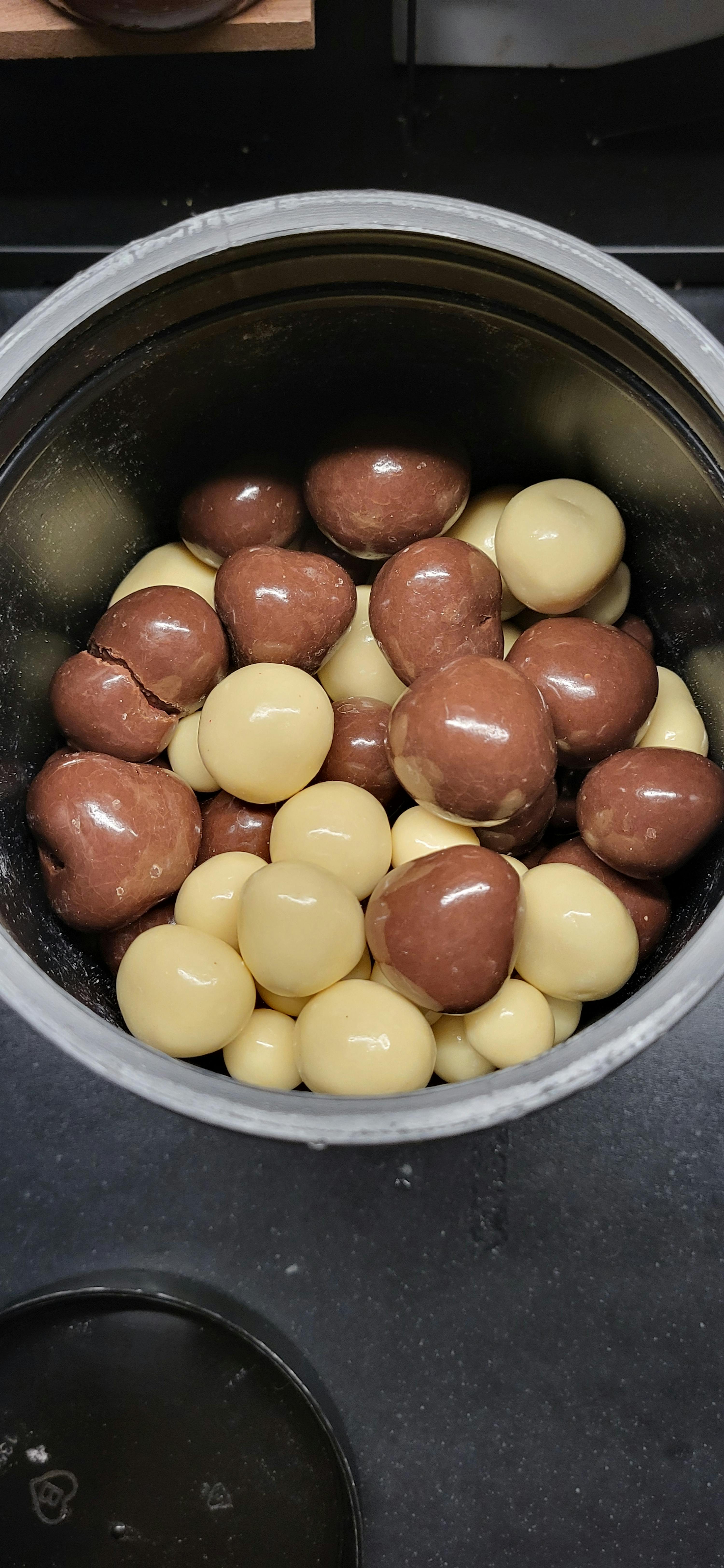 a metal container filled with chocolate covered nuts with a lid that says ' philips ' on it