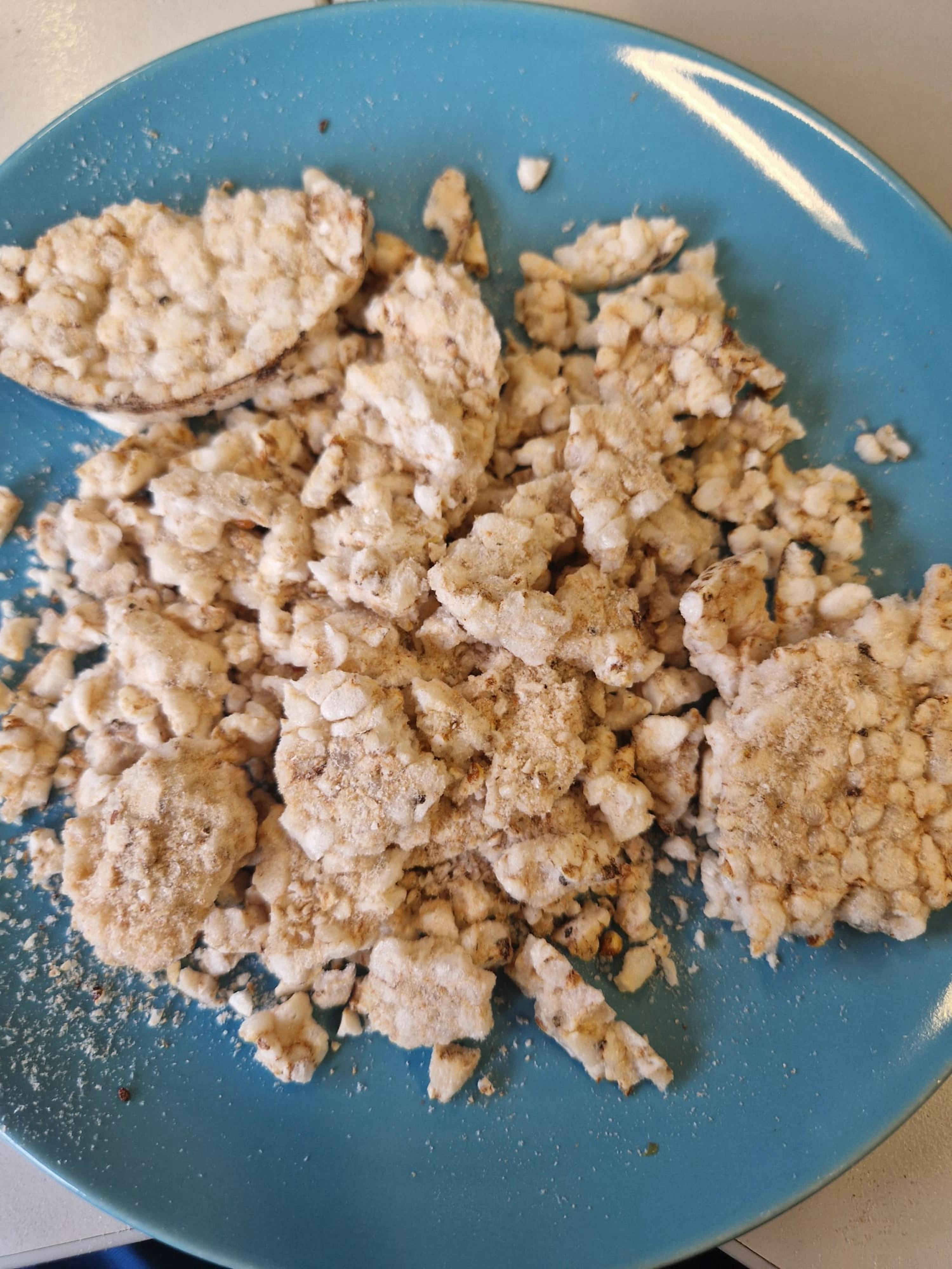 ein blauer Teller mit einem Haufen Essen auf einem Tisch