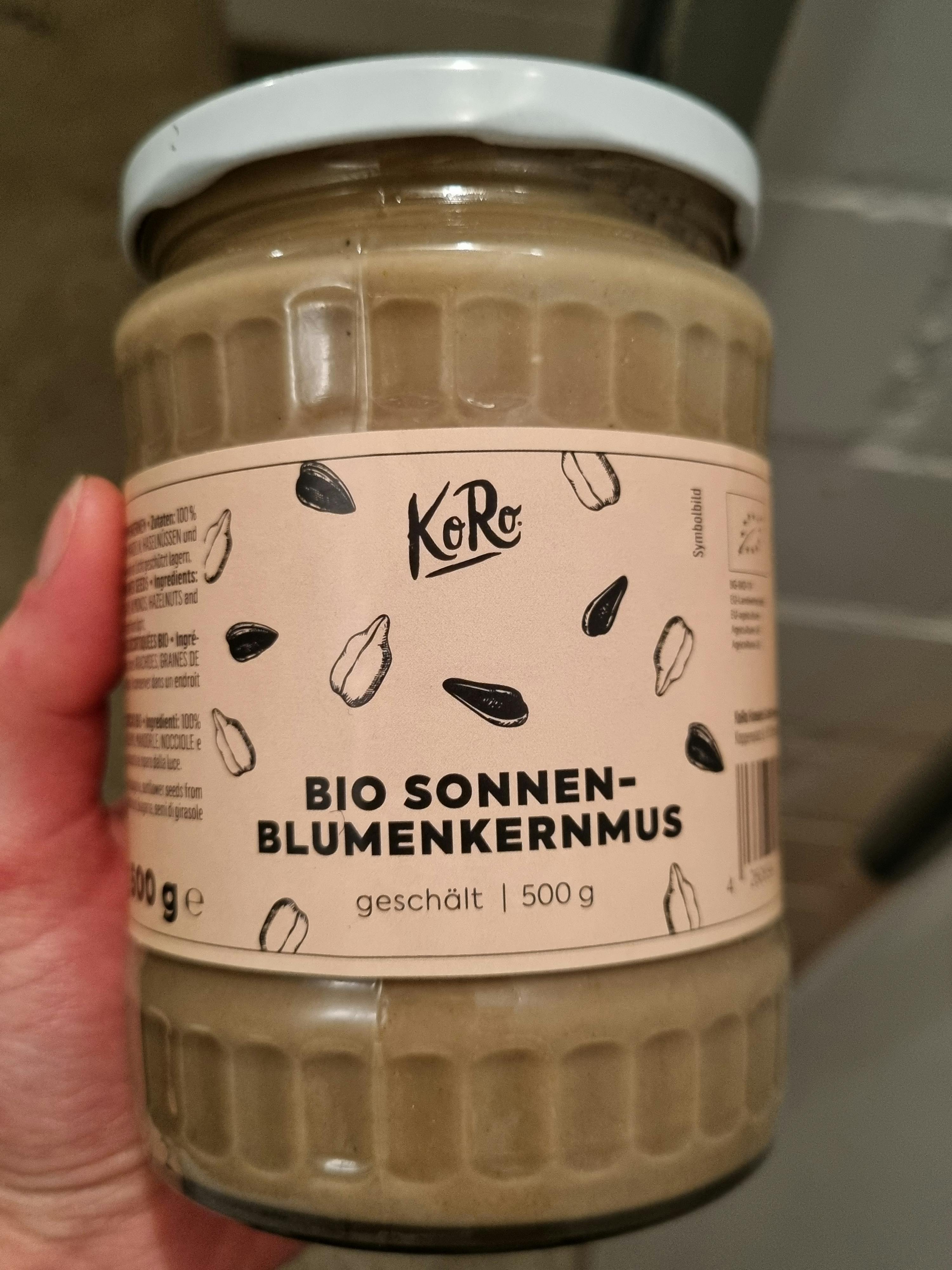 une personne tient un pot de beurre de tournesol bio