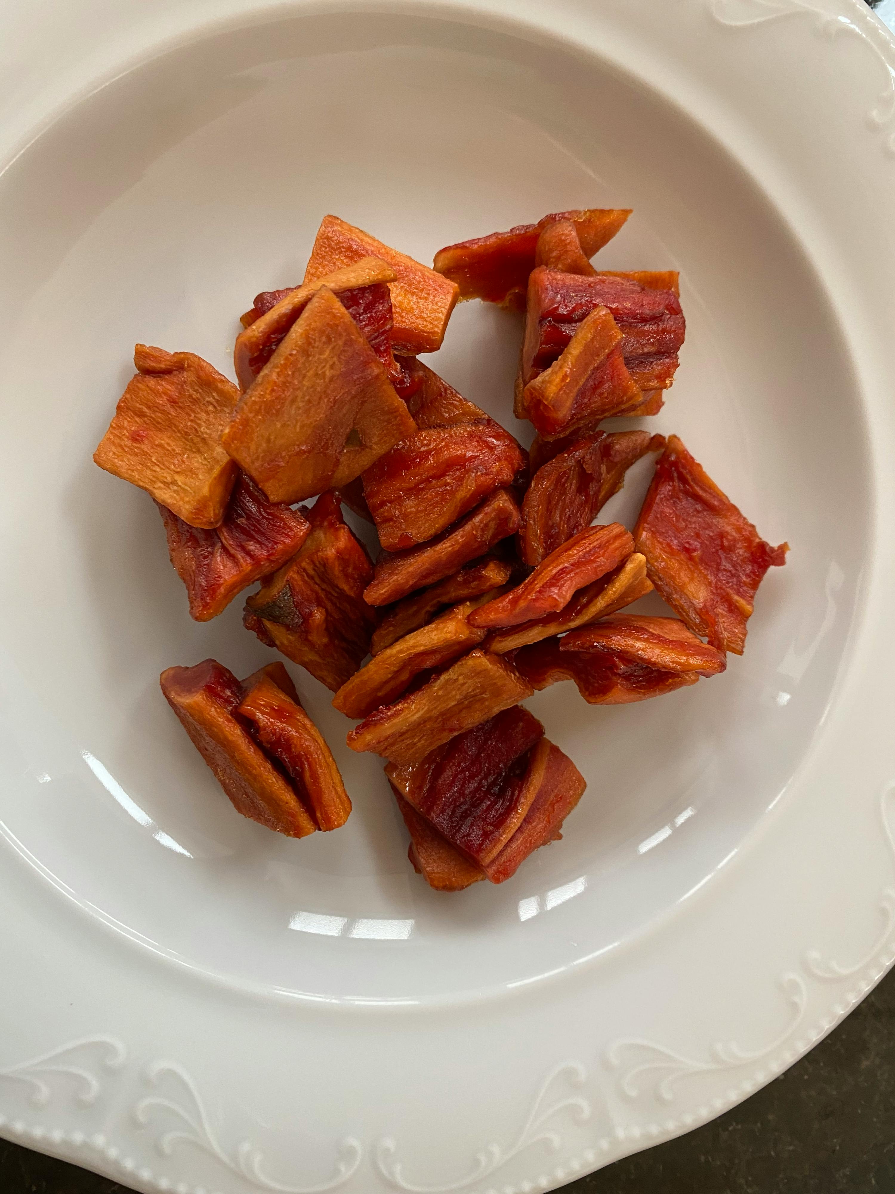 ein weißer Teller mit getrockneten Tomatenstücken