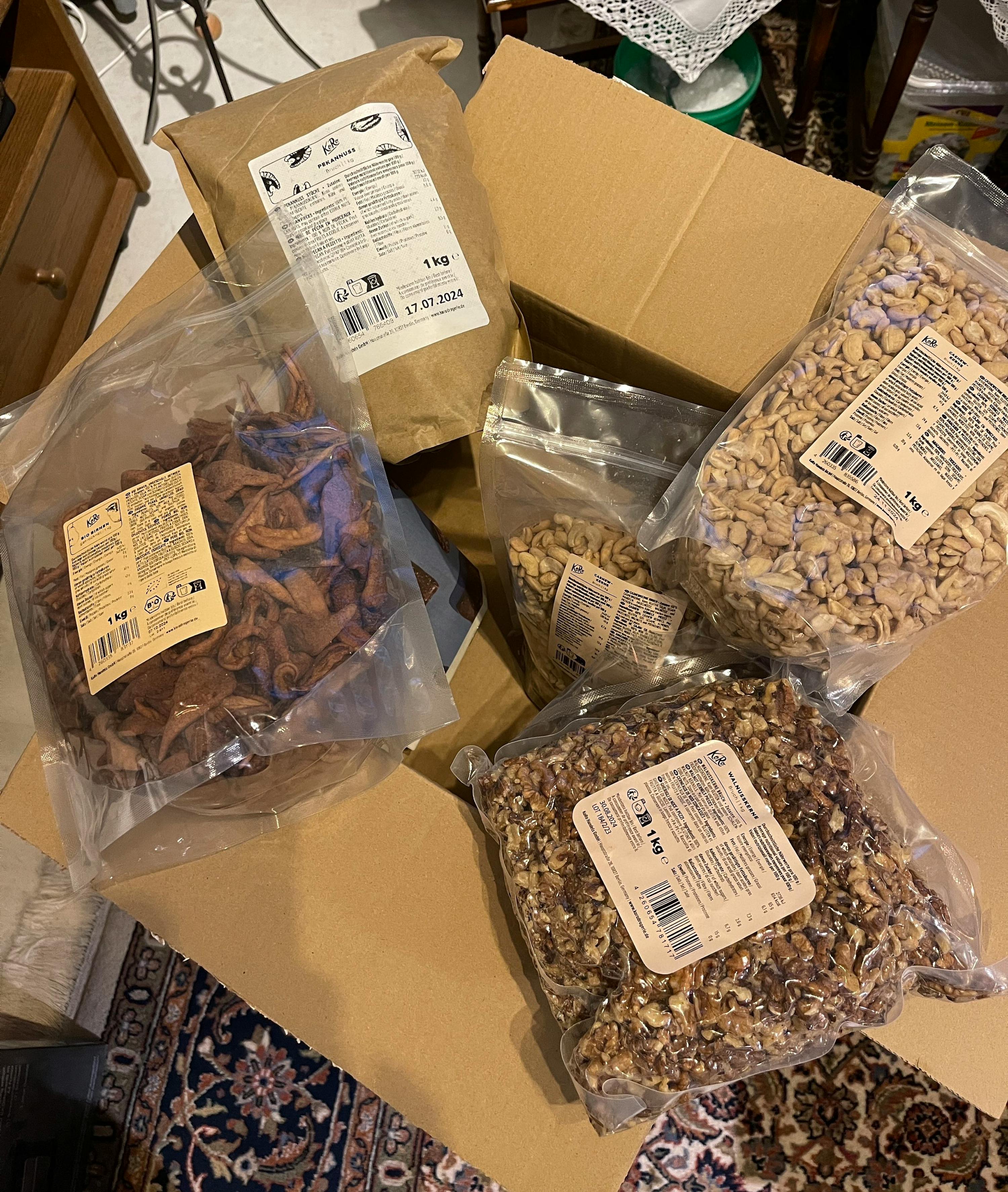 une boîte en carton remplie de différents types de noix et de fruits séchés