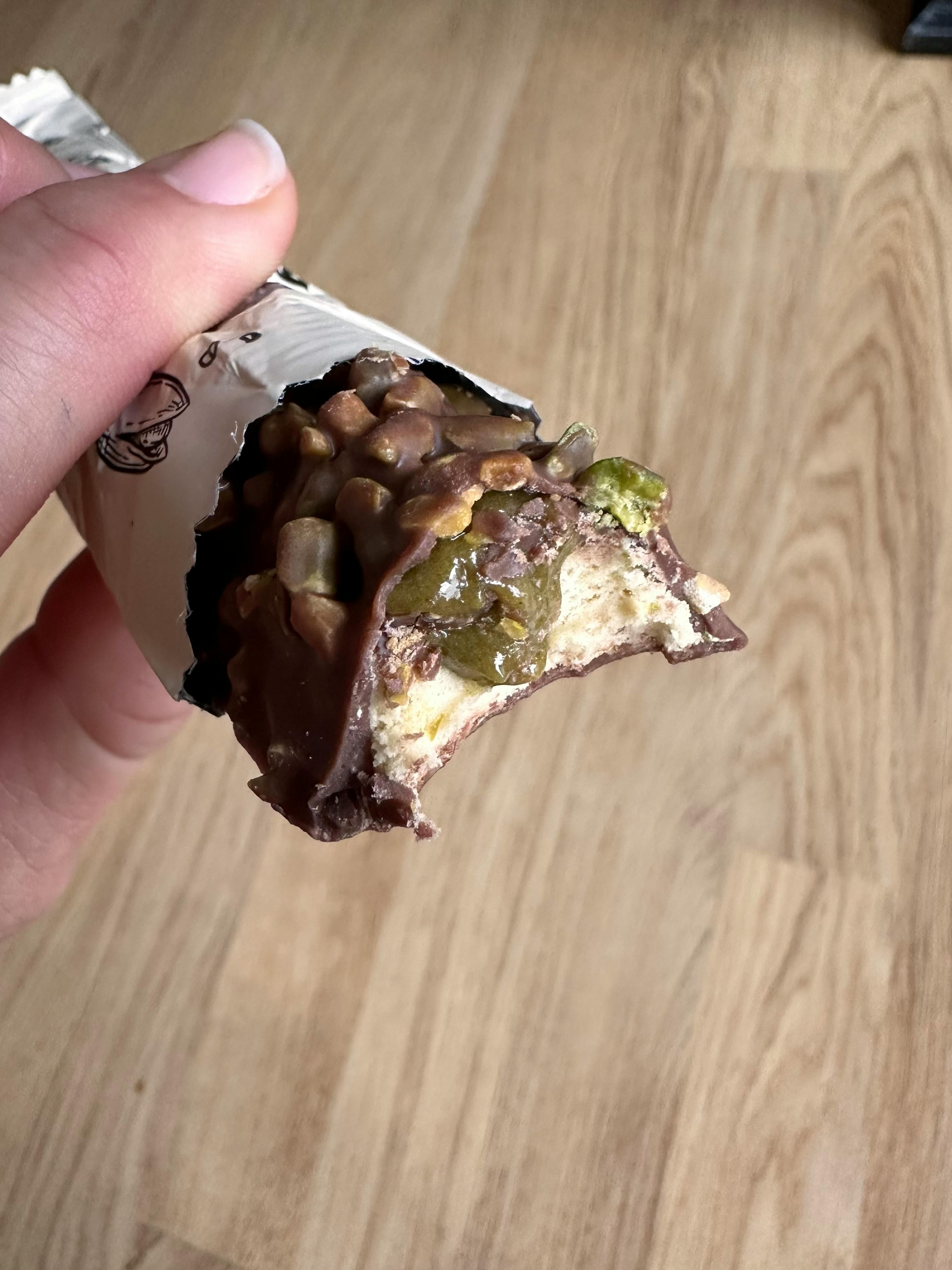 eine Person hält einen Schokoladenriegel mit einem Stück genommen