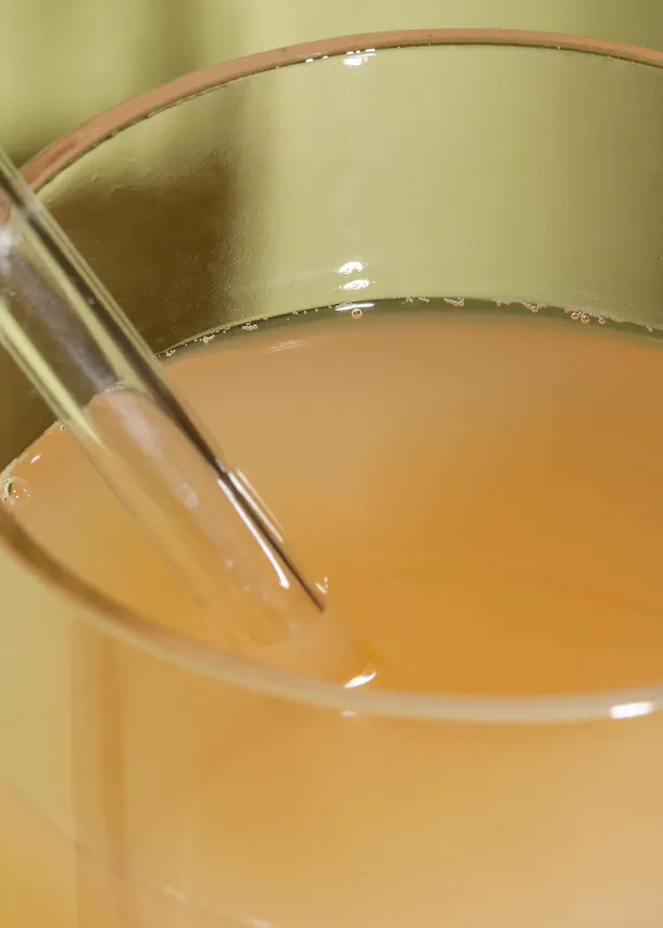 a glass of liquid with a straw sticking out of it