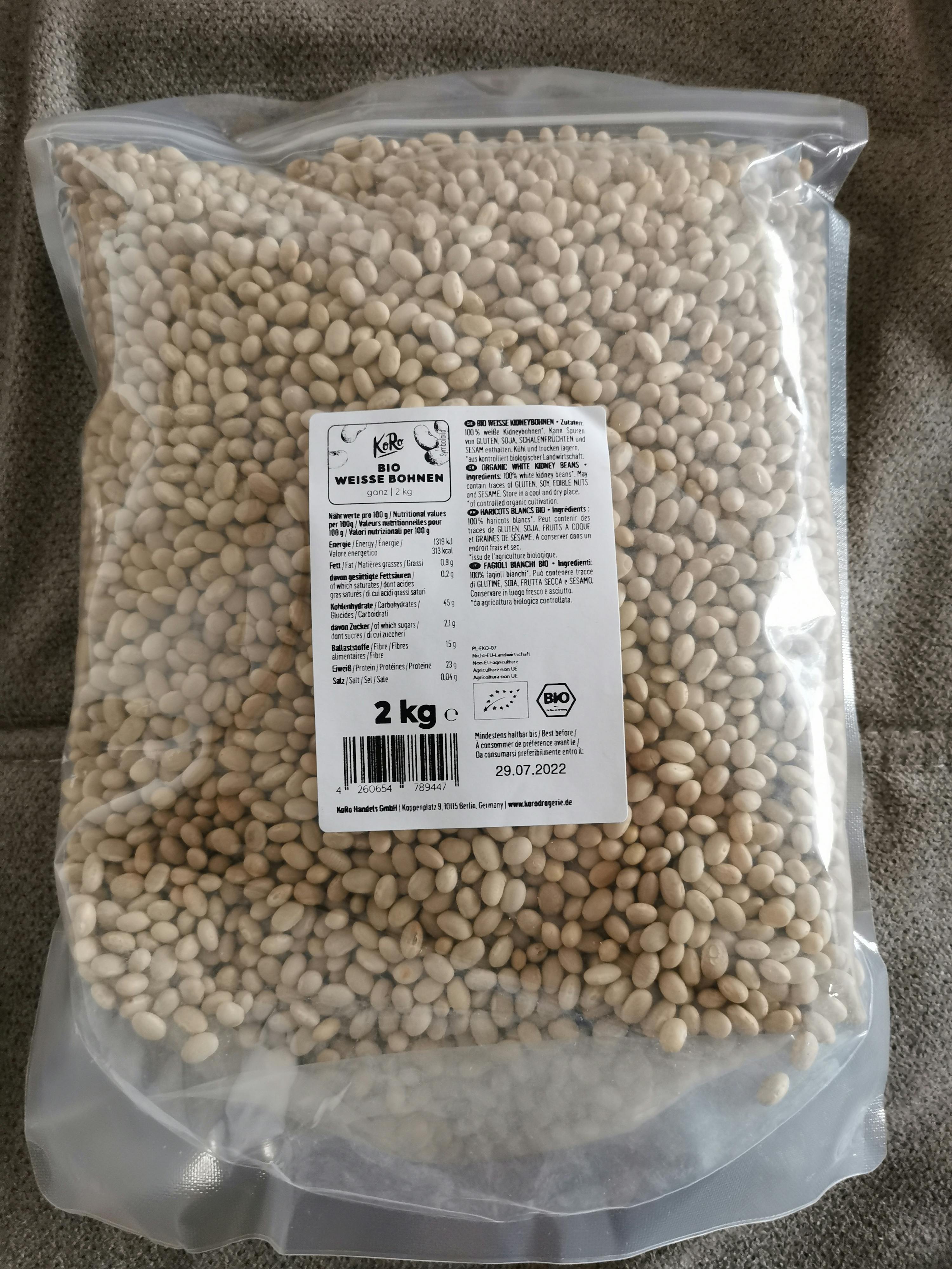 eine Plastiktüte mit weißen Bohnen steht auf einer Decke