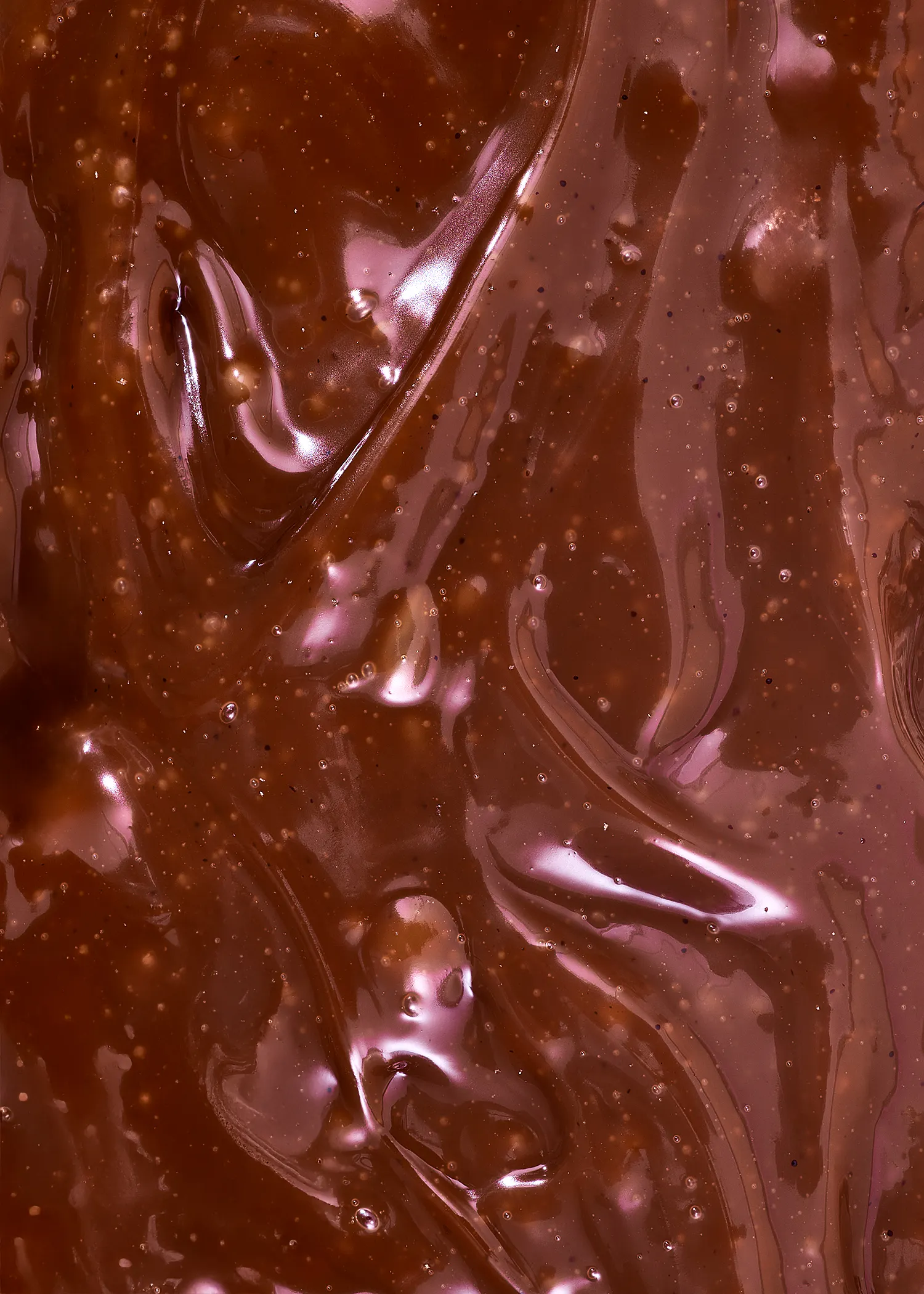 a close up of a chocolate sauce with bubbles in it