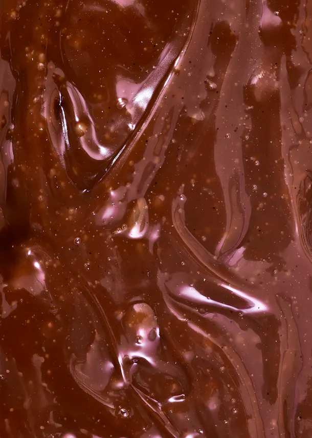 a close up of a chocolate sauce with bubbles in it