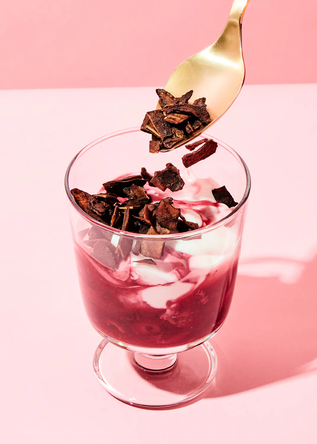 eine Schüssel mit einem roten und weißen Dessert wird mit einem Löffel gefüllt